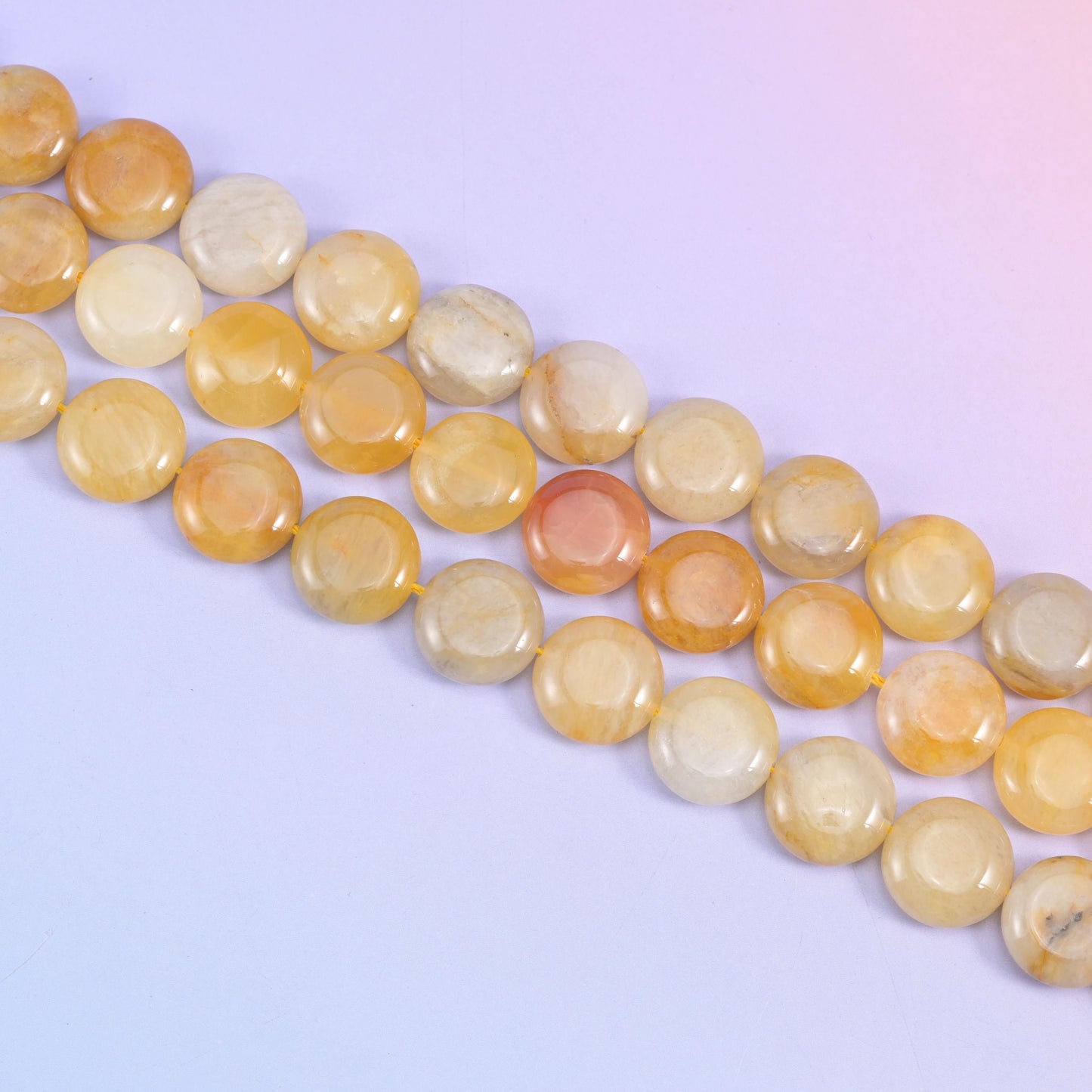 Yellow Jade coin beads with soft grey-brown veining running through the paler stone