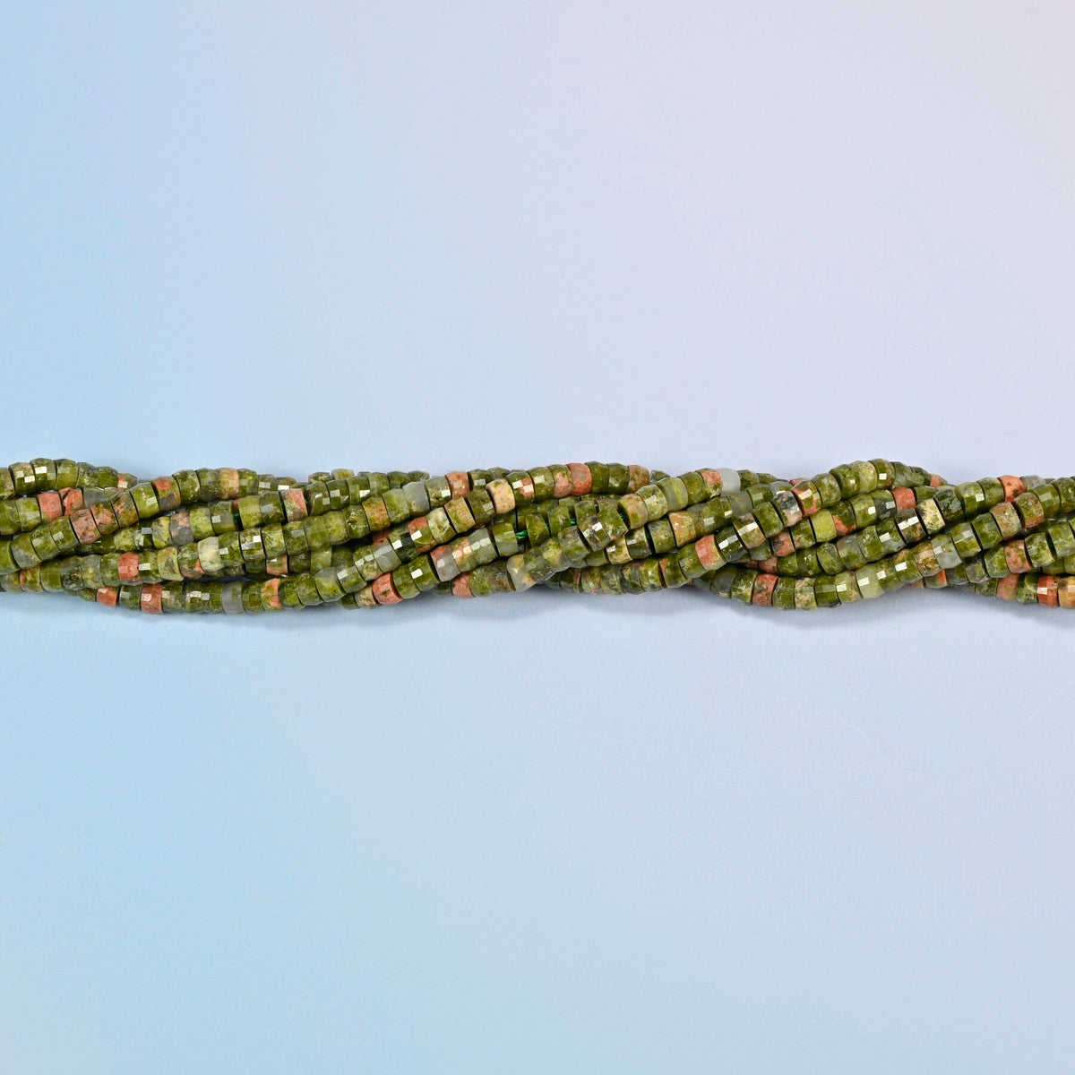 Strands of unakite faceted heishi disc beads twisted together in a horizontal row