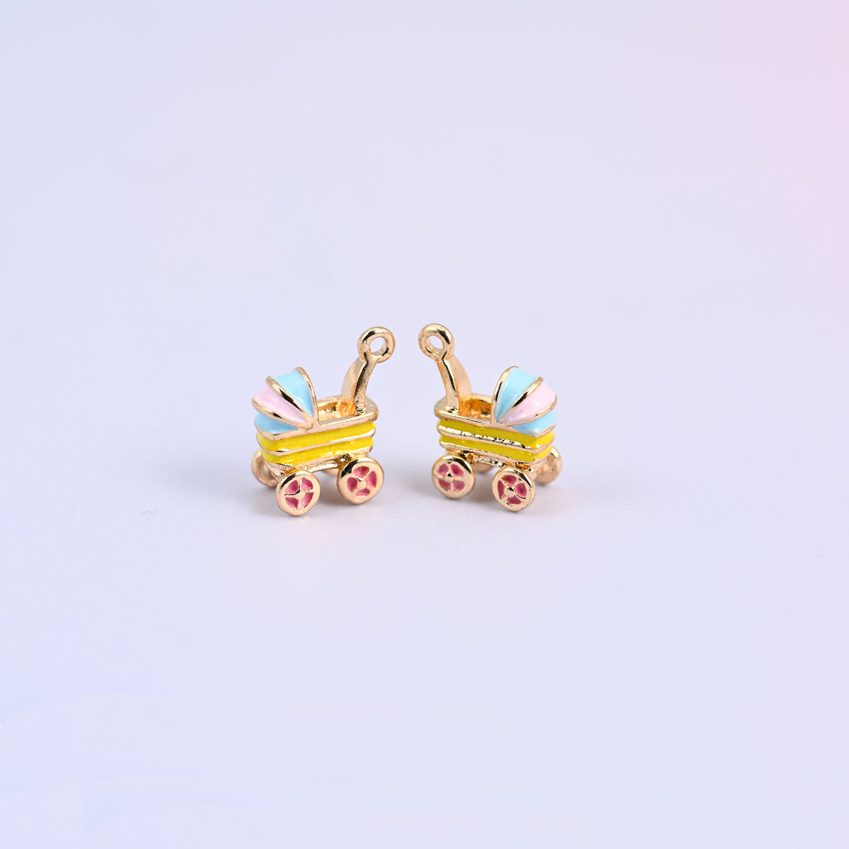 Two yellow stroller charms with pink and light blue striped hoods and pink flower-spoke wheels, 18K gold plated brass.