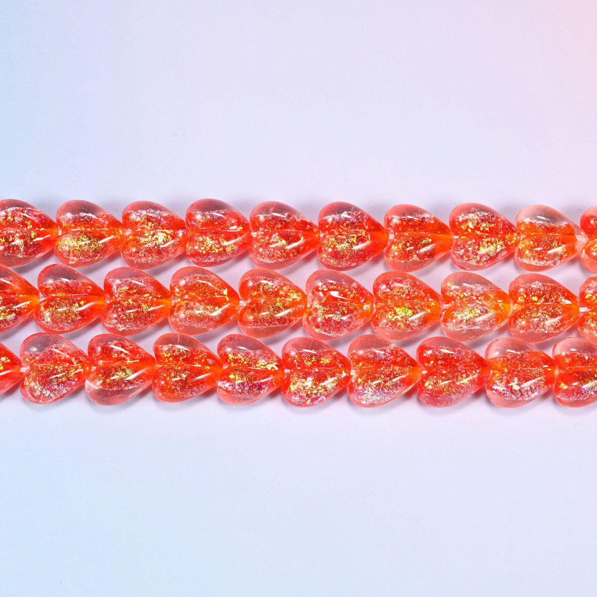 Iridescent Heart Glass Beads in warm coral-red