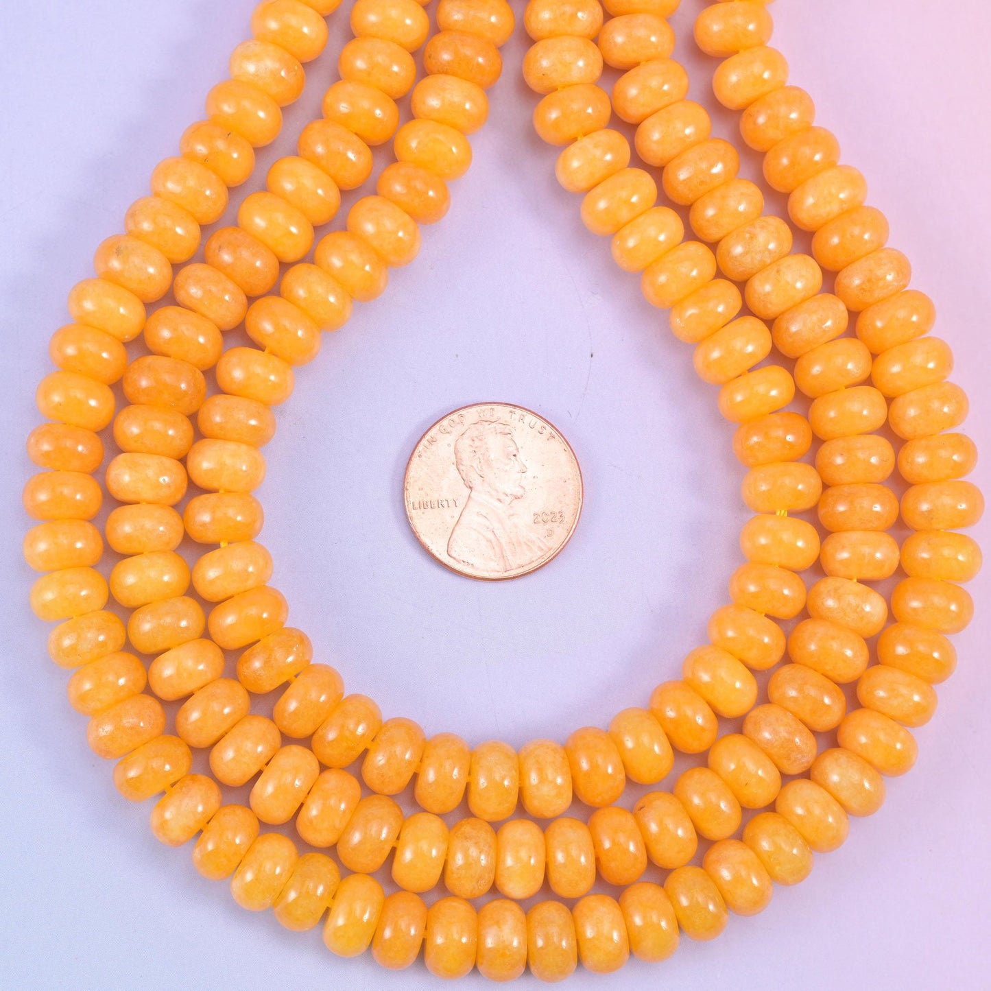Orange Dyed Jade smooth rondelle beads in a warm golden-orange hue, finished with a smooth, polished surface