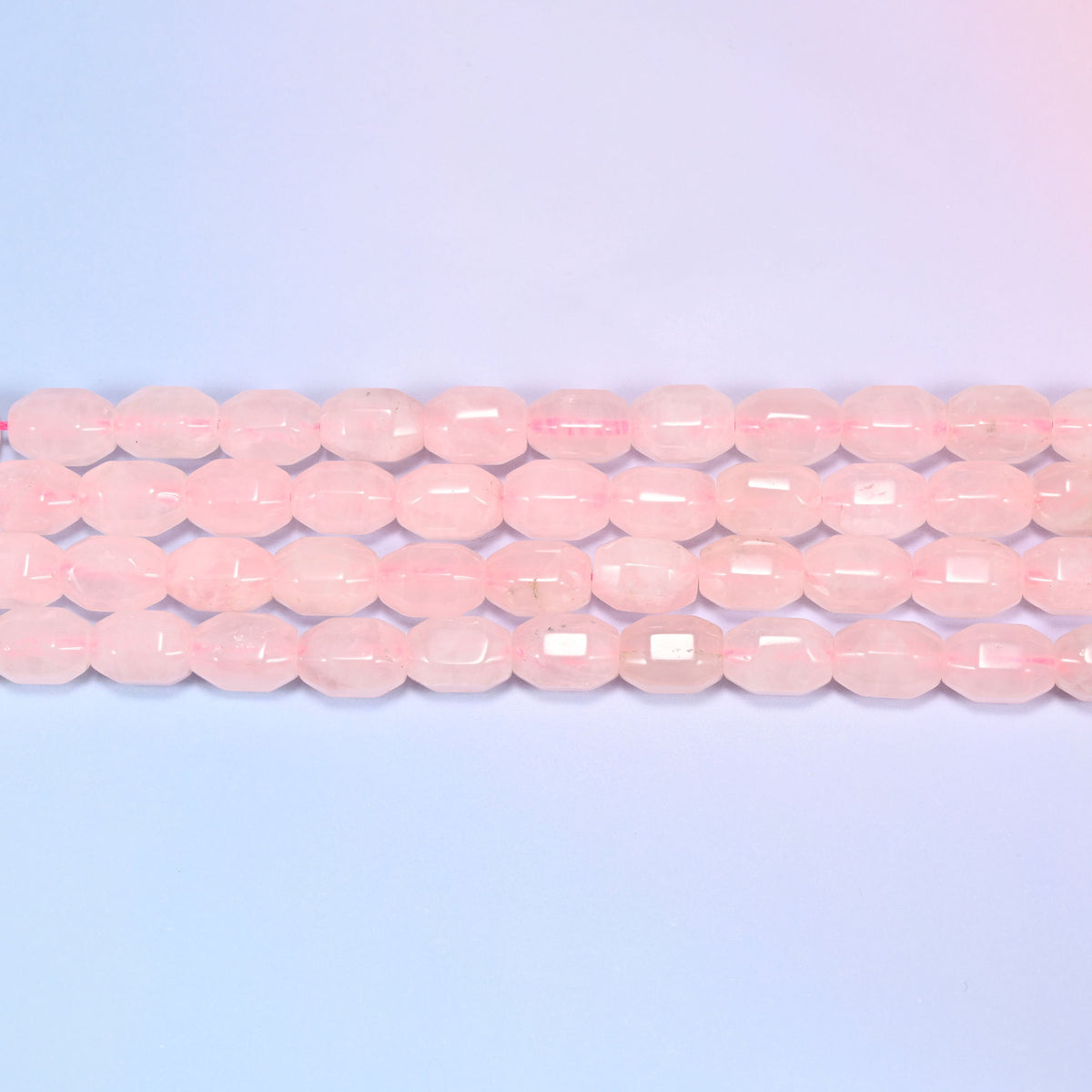 Natural Rose Quartz Faceted Barrel Beads in soft translucent blush pink.