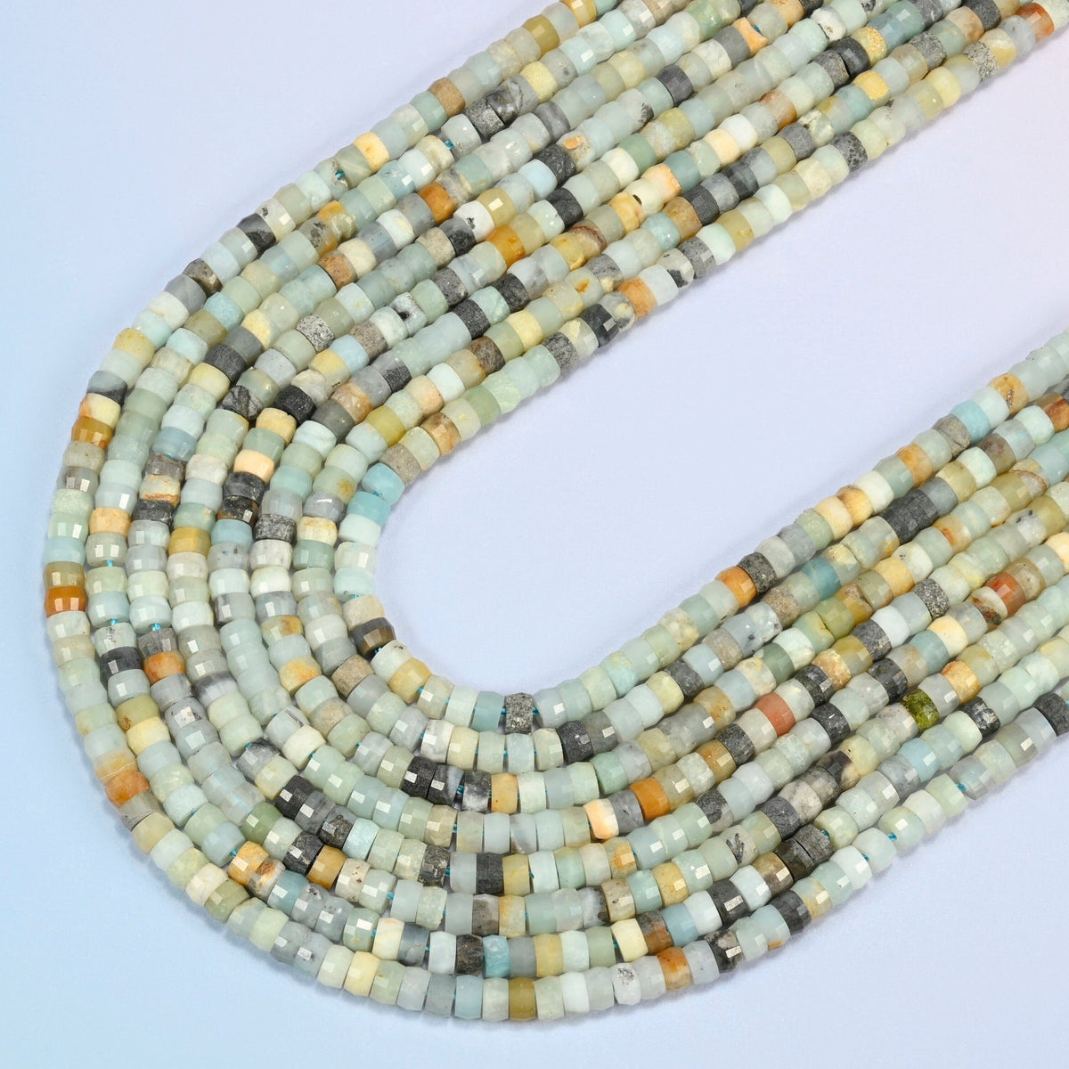 Multi-color amazonite faceted heishi disc beads in several strands curved into a wide U, light blue-green, cream and gray stone