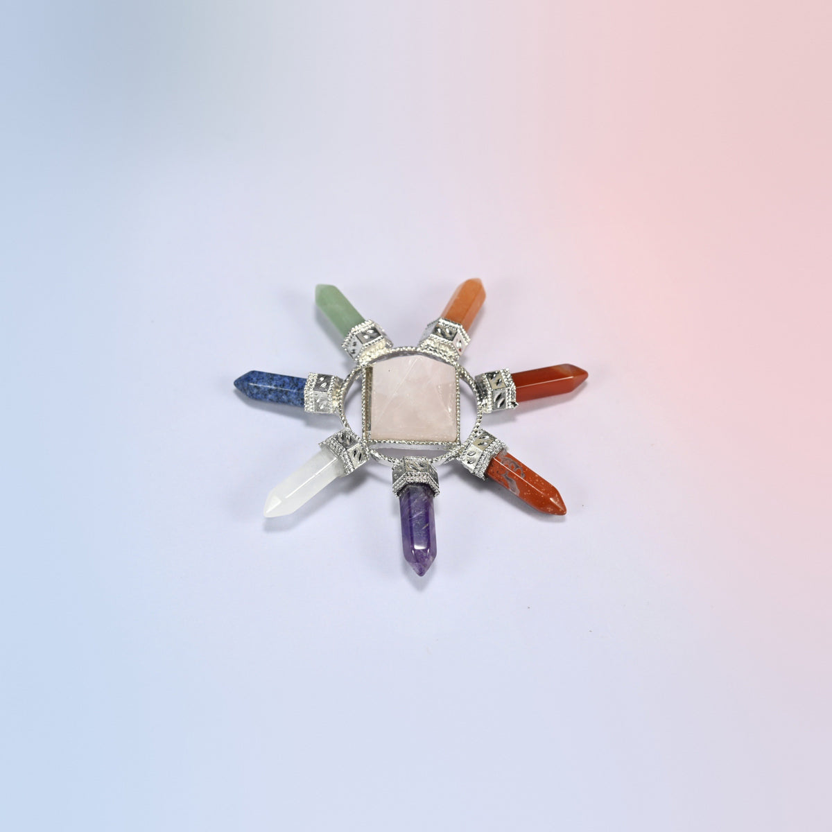 Crystal energy generator with a pink rose quartz center pyramid and seven chakra crystal points in a silver-tone frame