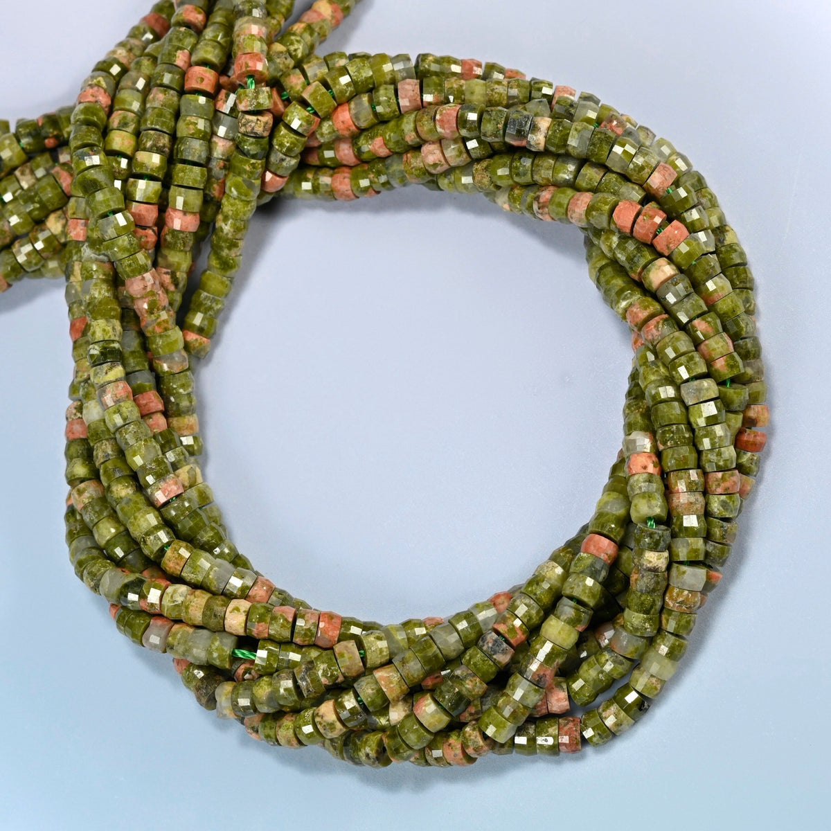 Unakite faceted heishi disc beads coiled into overlapping loops, whole strands of green and pink stone