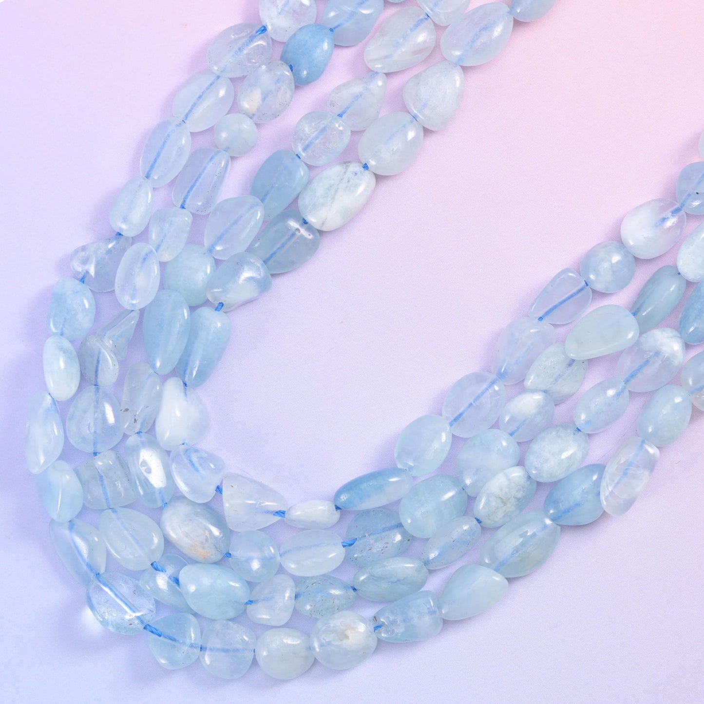 Looped aquamarine nugget strands showing frosted blue tone along the full length