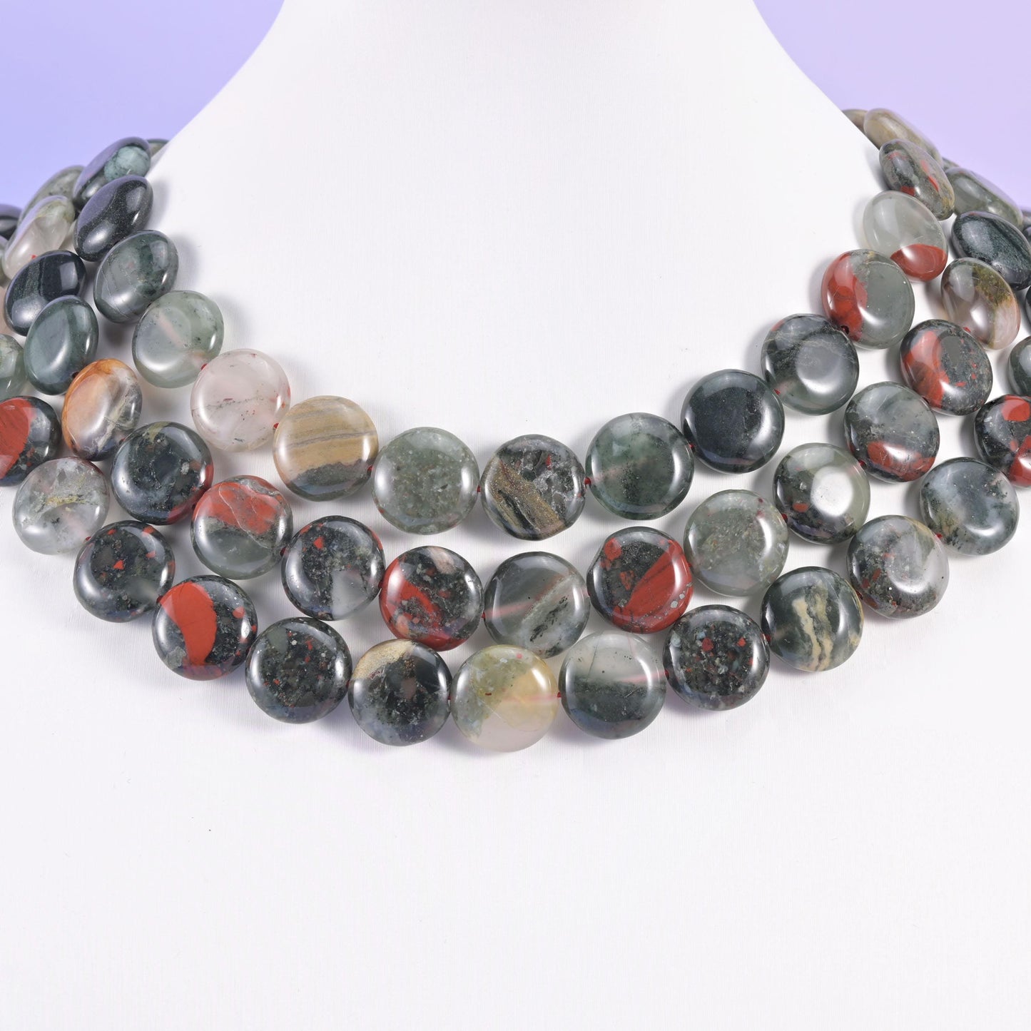 Bloodstone coin beads layered across a white neck display form