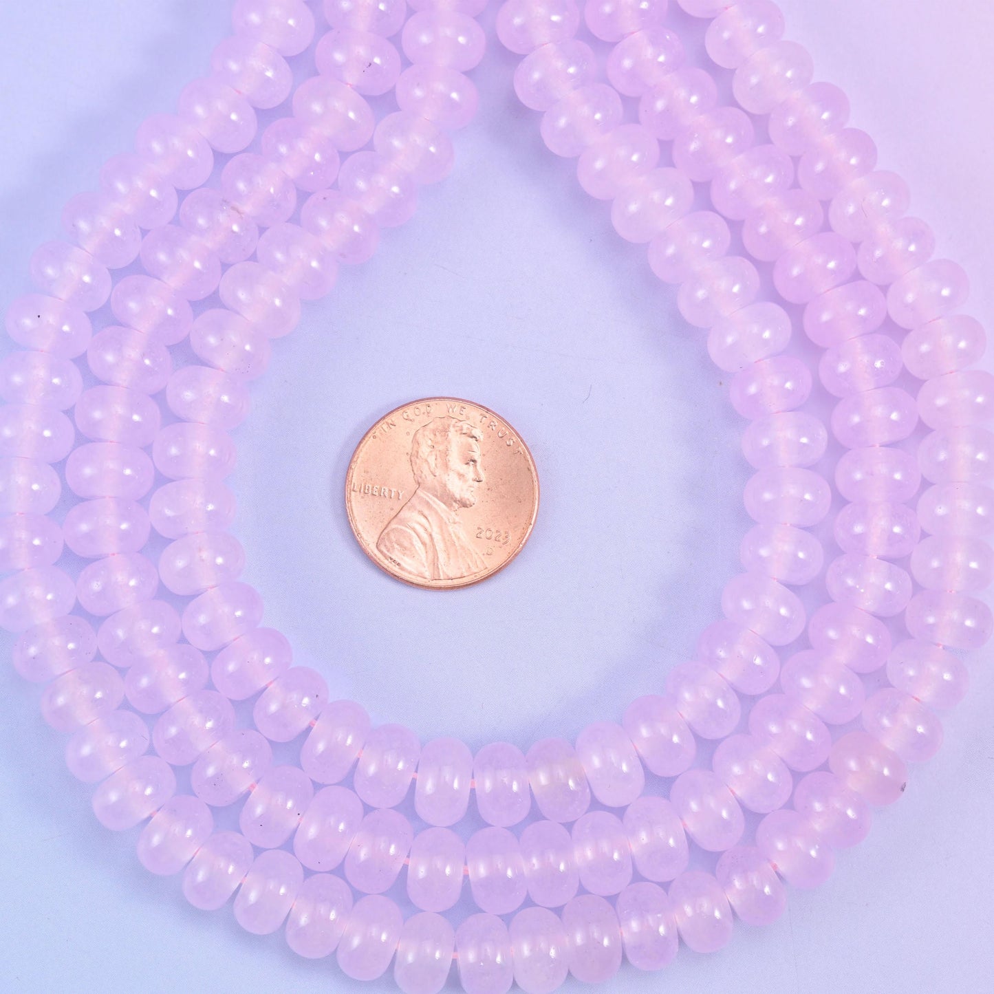 A soft translucent lavender-pink, polished to a clean shine and cut small at 5x8mm — around seventy-five rondelles to the strand, enough for a full bracelet with plenty left over.