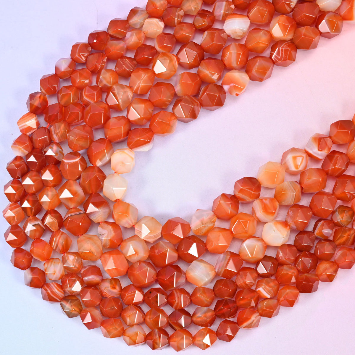 Dyed Red Stripe Agate diamond star cut beads, strands crossing in a V, dyed red holding an even tone over natural white agate bands