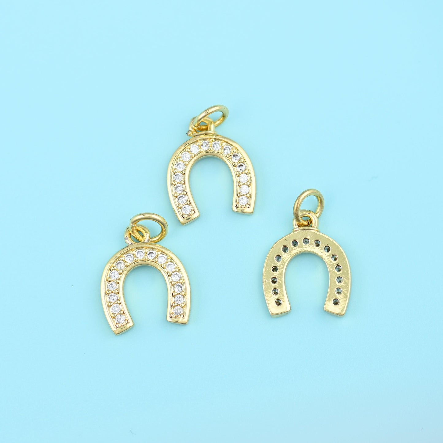 A slim upturned horseshoe set right around the arch with a row of small bright zircons, the gold left plain on the back and…