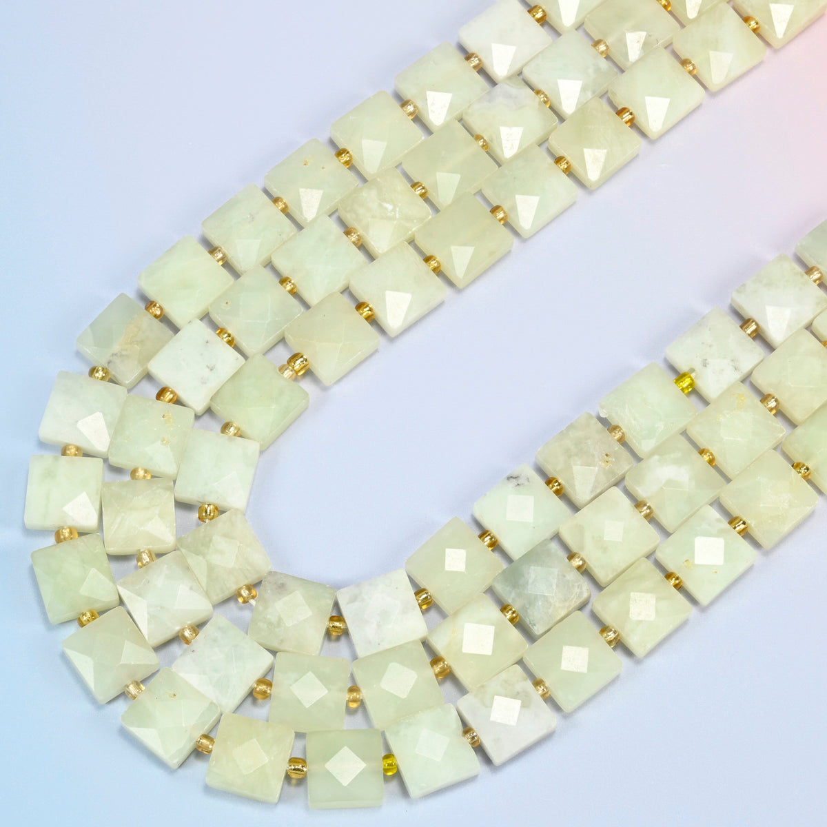 New Jade faceted flat square beads in several strands curved into a wide U, light yellow-green stone with soft white veins