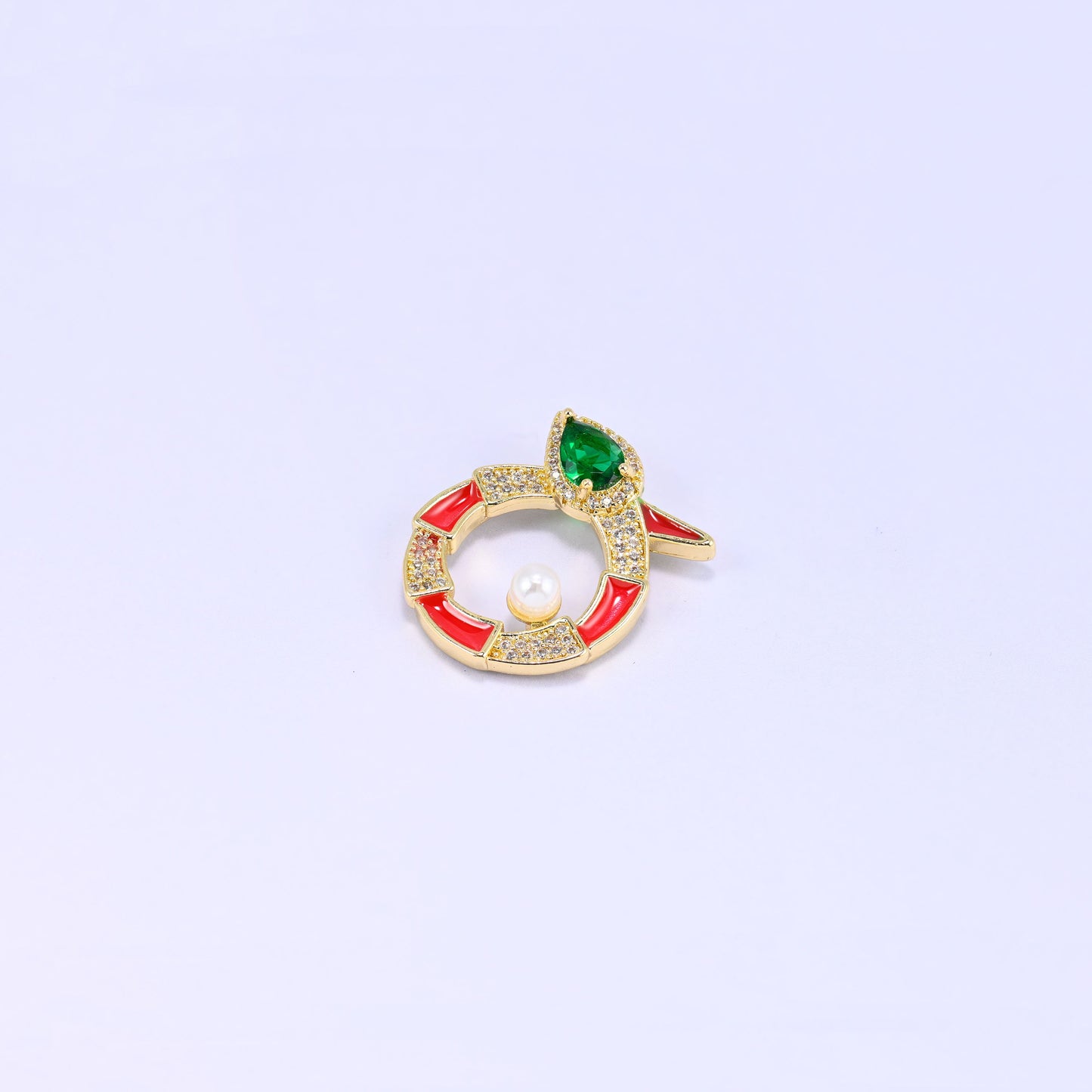 Single round snake charm on lavender, the coiled gold body banded in red enamel and clear zircon with a small pearl set inside the ring.