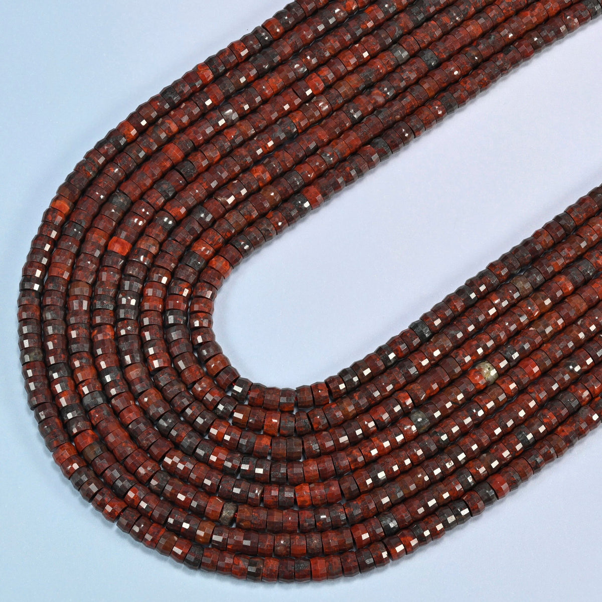 Zhanguo red agate faceted heishi disc beads in several strands curved into a wide U, deep brick red and dark brown stone