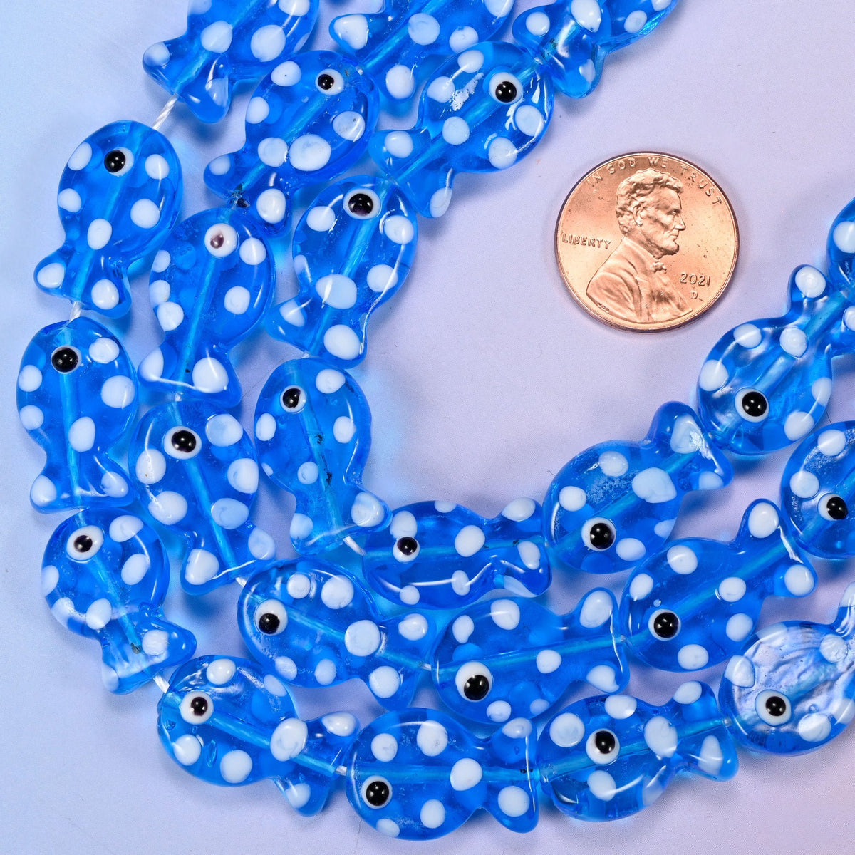 Moulded fish shaped transparent blue glass beads