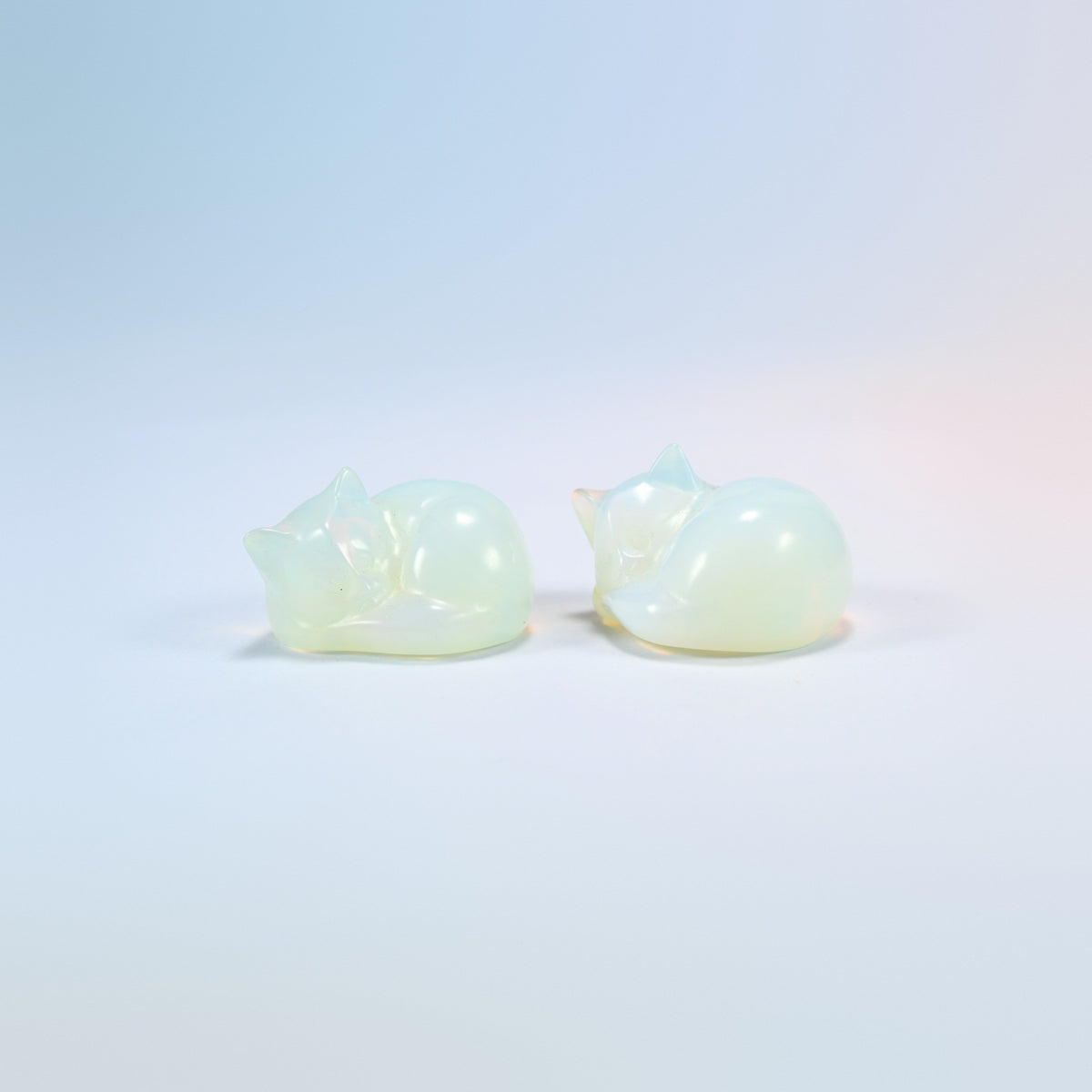 Two opalite sleeping cat carvings, 1.5 inch, glowing man-made glass