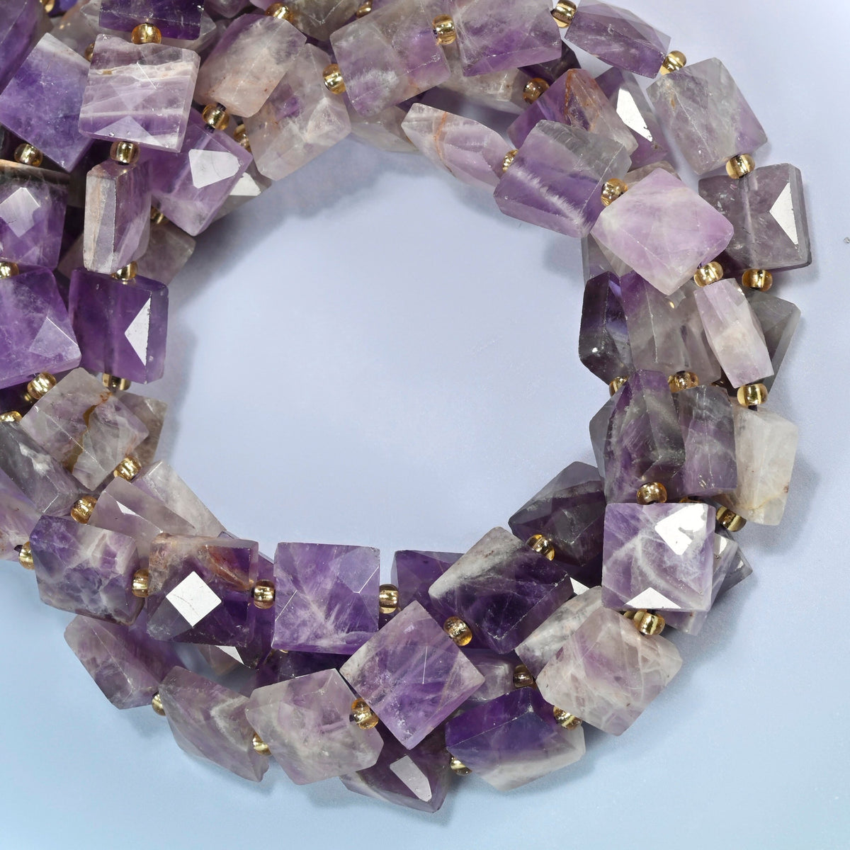 Natural amethyst faceted flat square beads coiled into overlapping loops, whole strands of purple and lavender stone