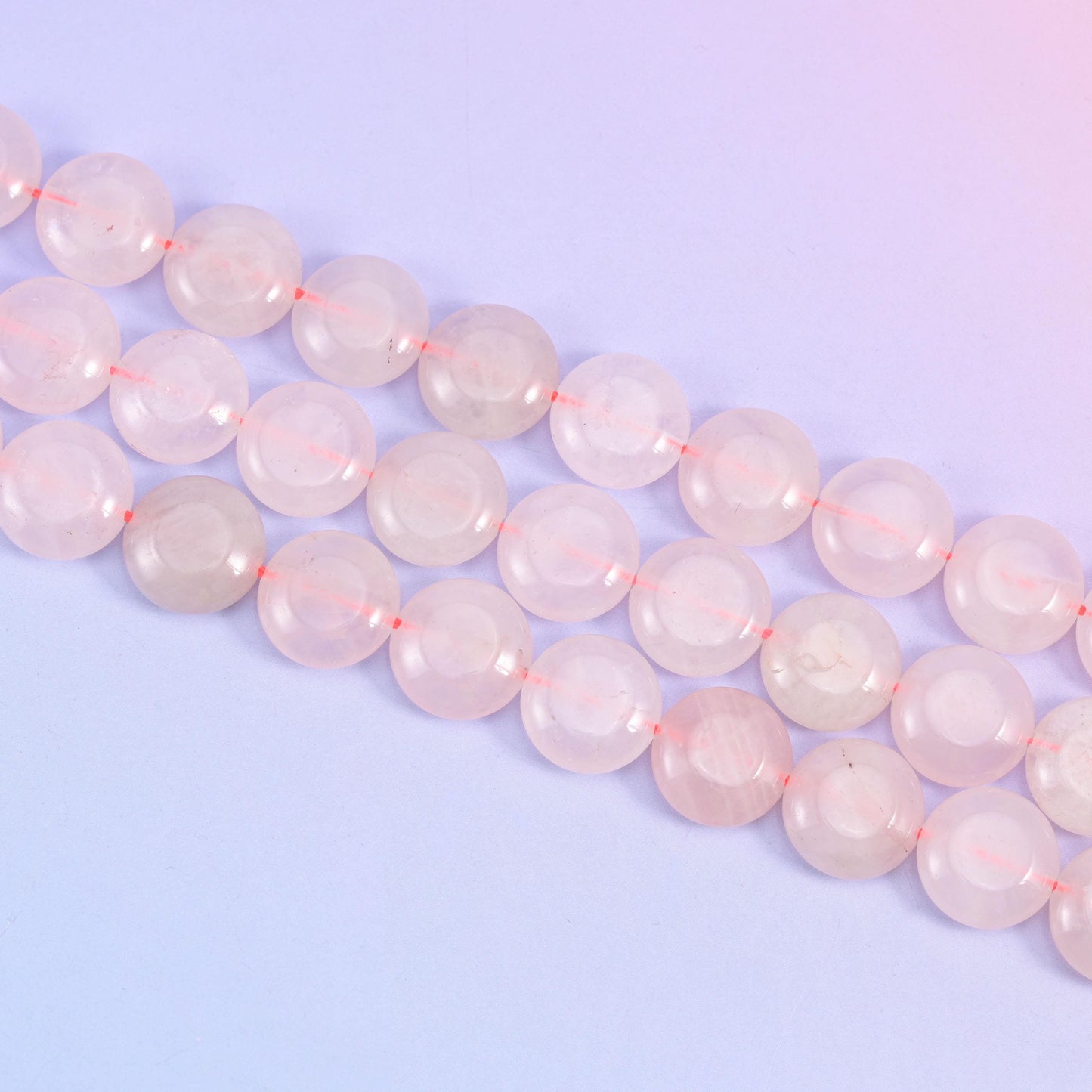 Rose Quartz coin beads with cloudy white veils drifting through the pink stone