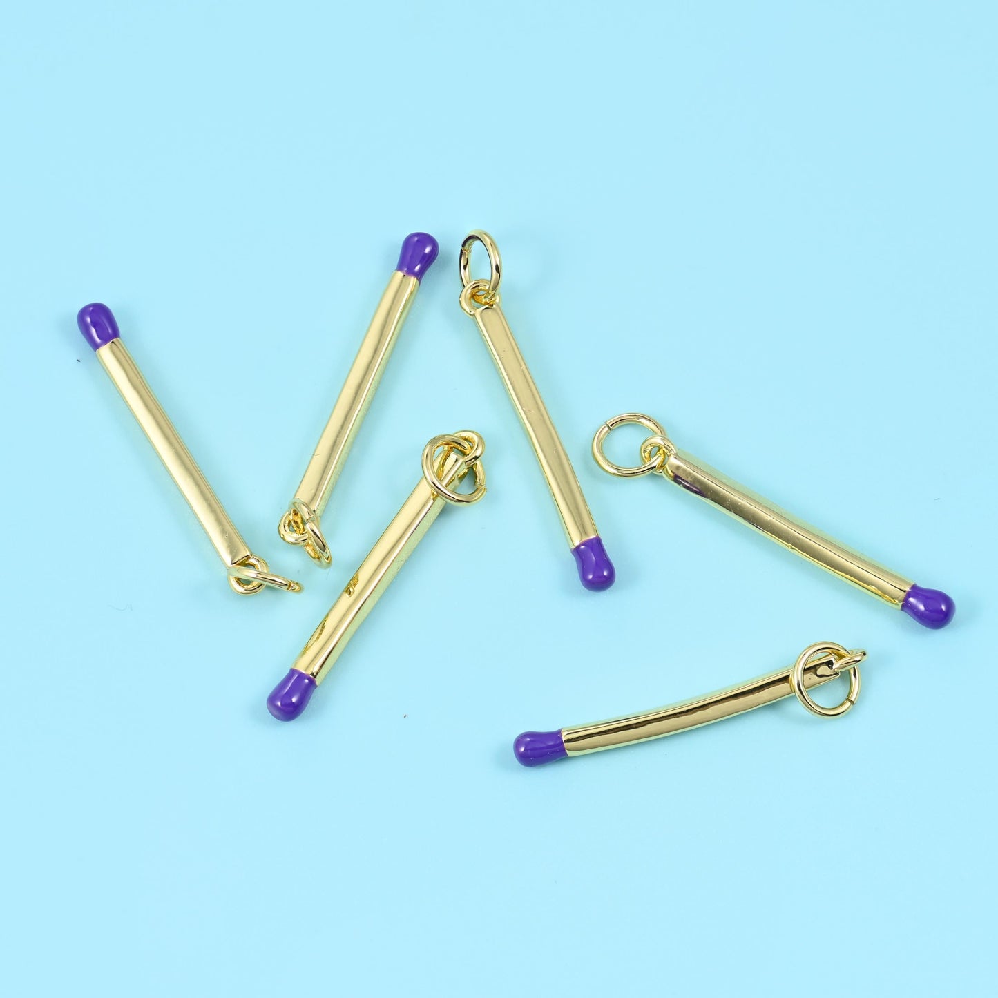 A tiny matchstick, done as a slim polished gold bar with one enamelled tip for the head — navy, black, yellow, lime, pink,…
