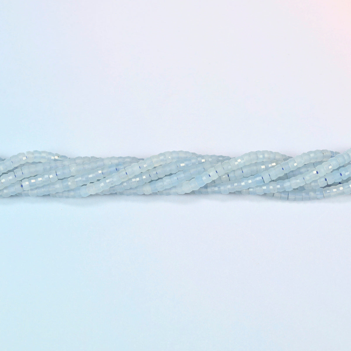 Strands of aquamarine chalcedony faceted heishi disc beads twisted together in a horizontal row