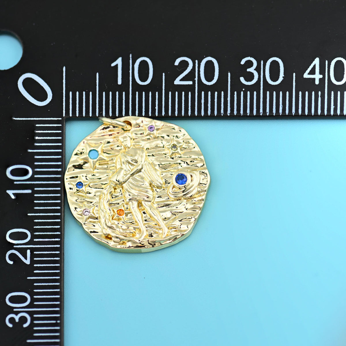 18K gold plated zodiac pendant beside a millimetre ruler, disc measuring about 21mm across