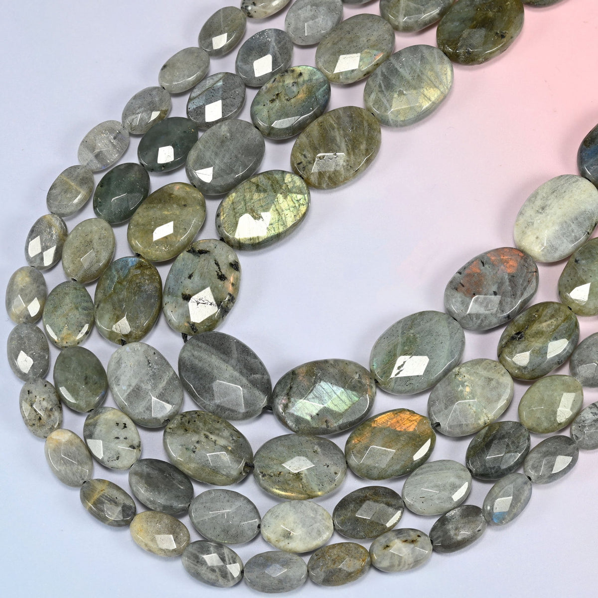 Gray Labradorite faceted oval beads curving in a long loop, blue flash sweeping across the oval faces