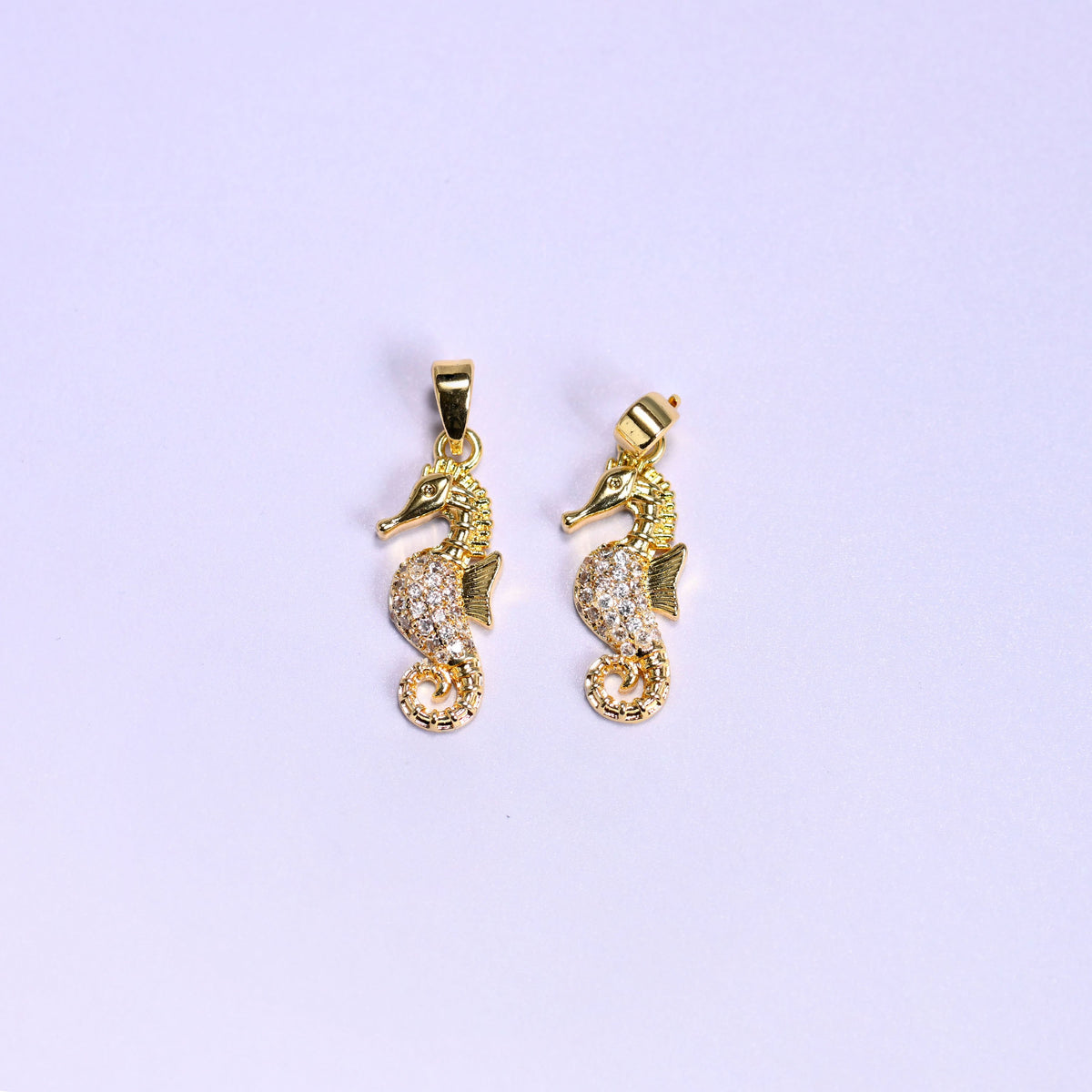 Gold colourway of the sea horse zirconia pendant, two 18K gold plated charms side by side, one square to camera and one angled to show the snap bail.