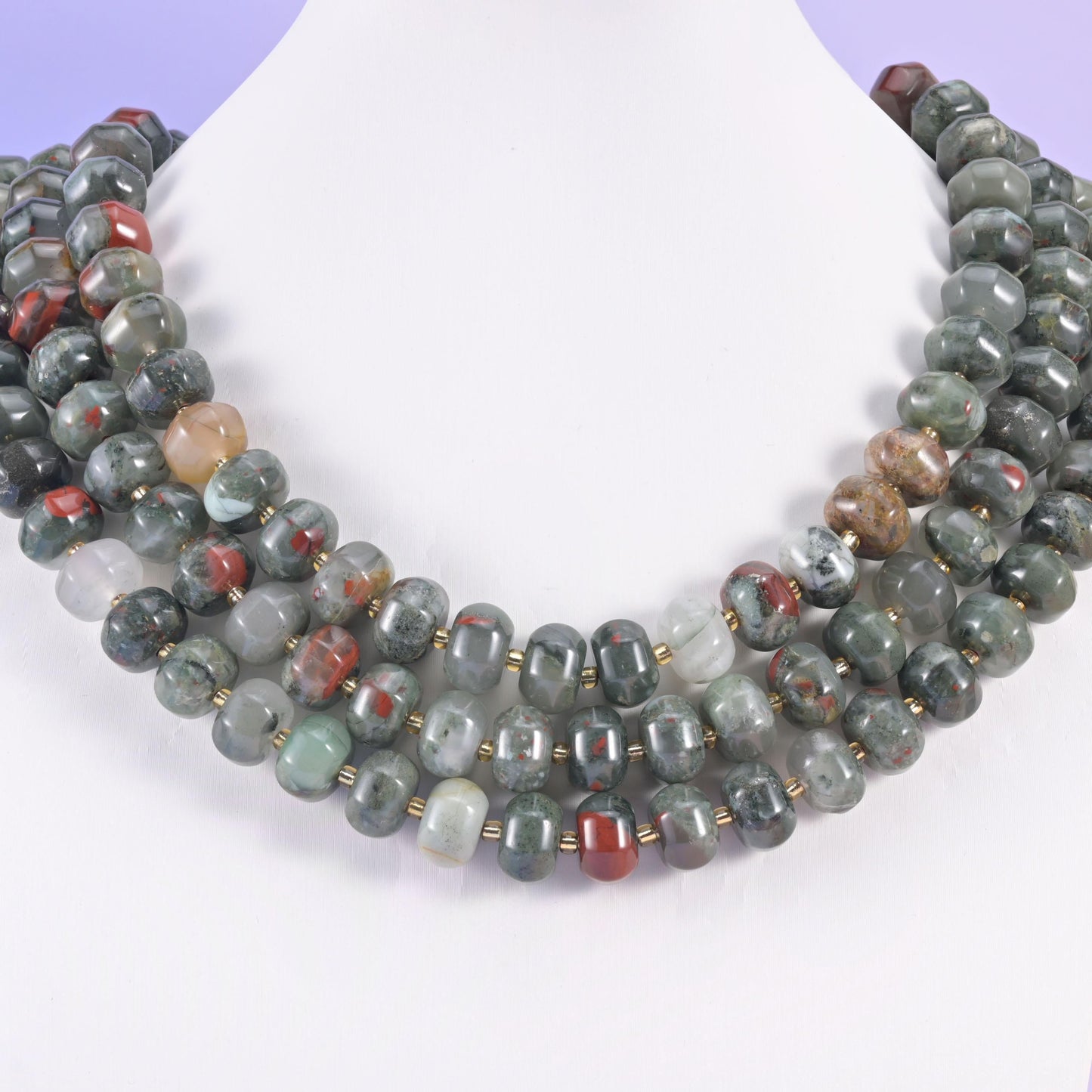 Multi-strand pumpkin rondelle necklace on a white display bust, sage green beads flecked with rust red