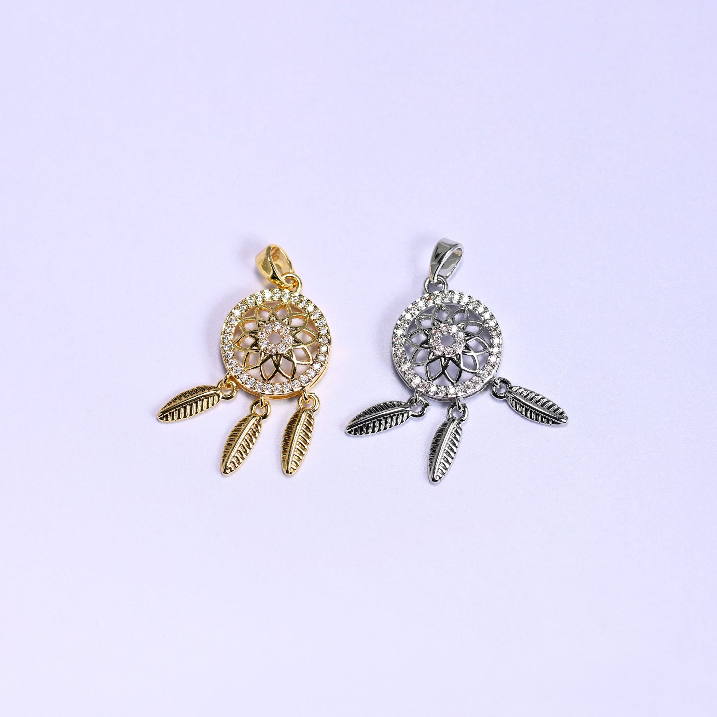 Dream Catcher Zirconia Charms colorway pair, gold plated on the left and silver tone on the right, each with an openwork medallion and feathers.