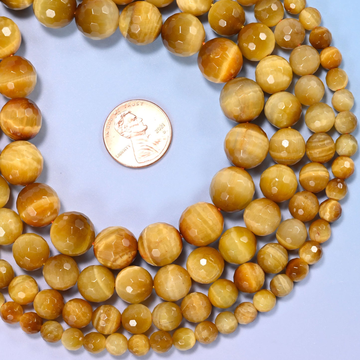 Group of golden brown gold tiger eye round beads showing natural color and pattern variation.