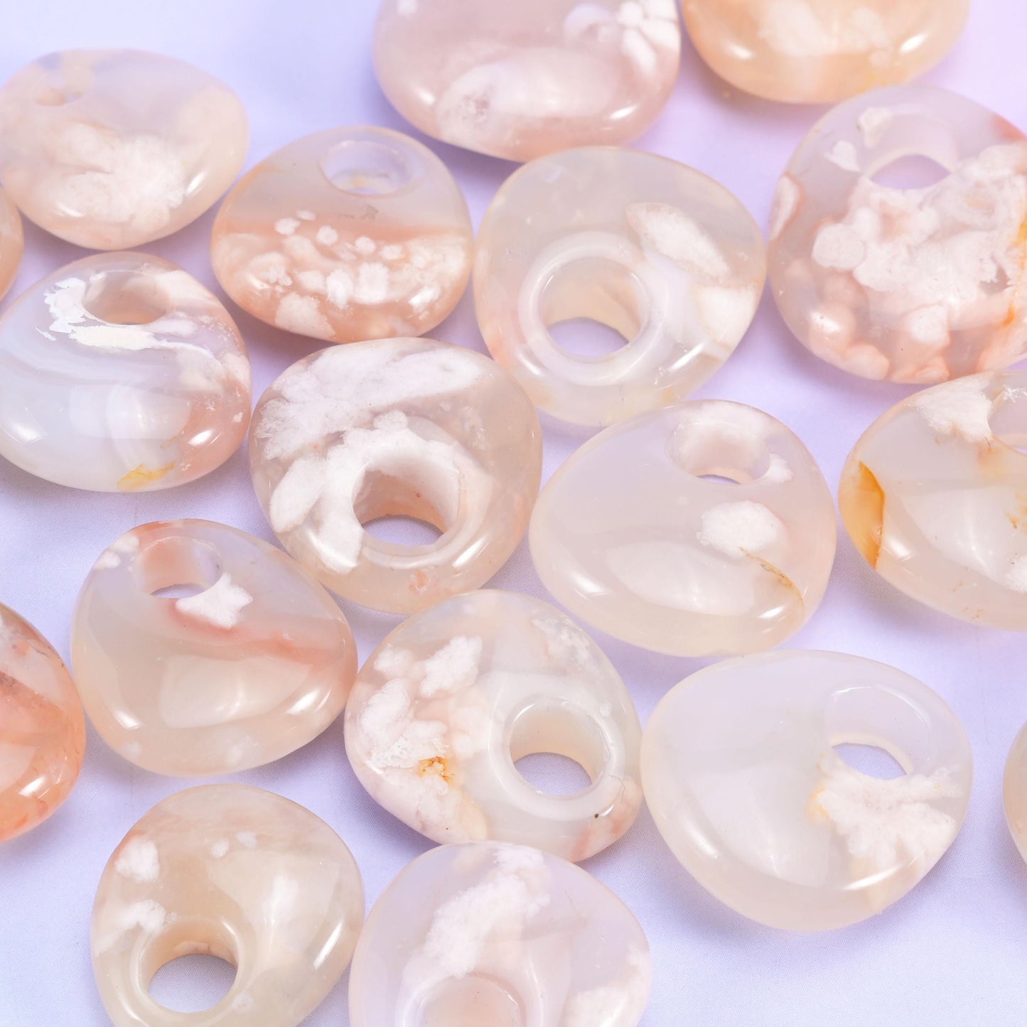 Pale cream and blush agate discs, polished until softly translucent at the rim, scattered with white plume clusters