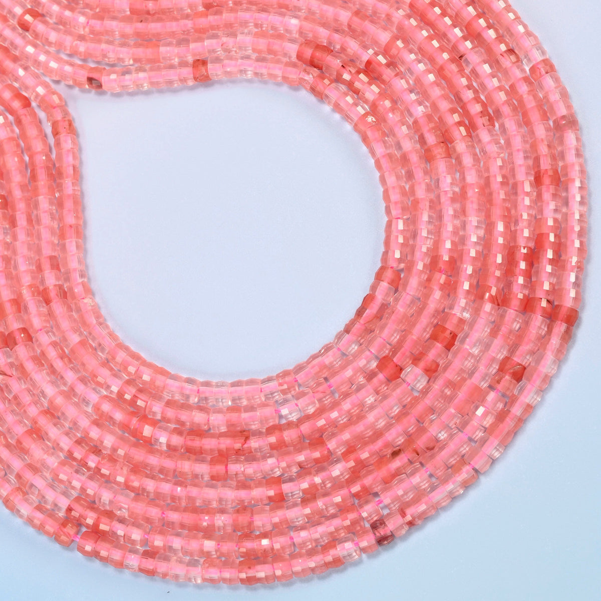 Melon quartz faceted heishi disc beads curved into an open loop, translucent pink beads with coral pink streaks