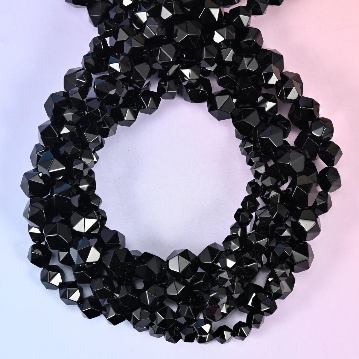 Black Onyx star cut beads coiled in a loop, approximately 38 beads per 10mm strand