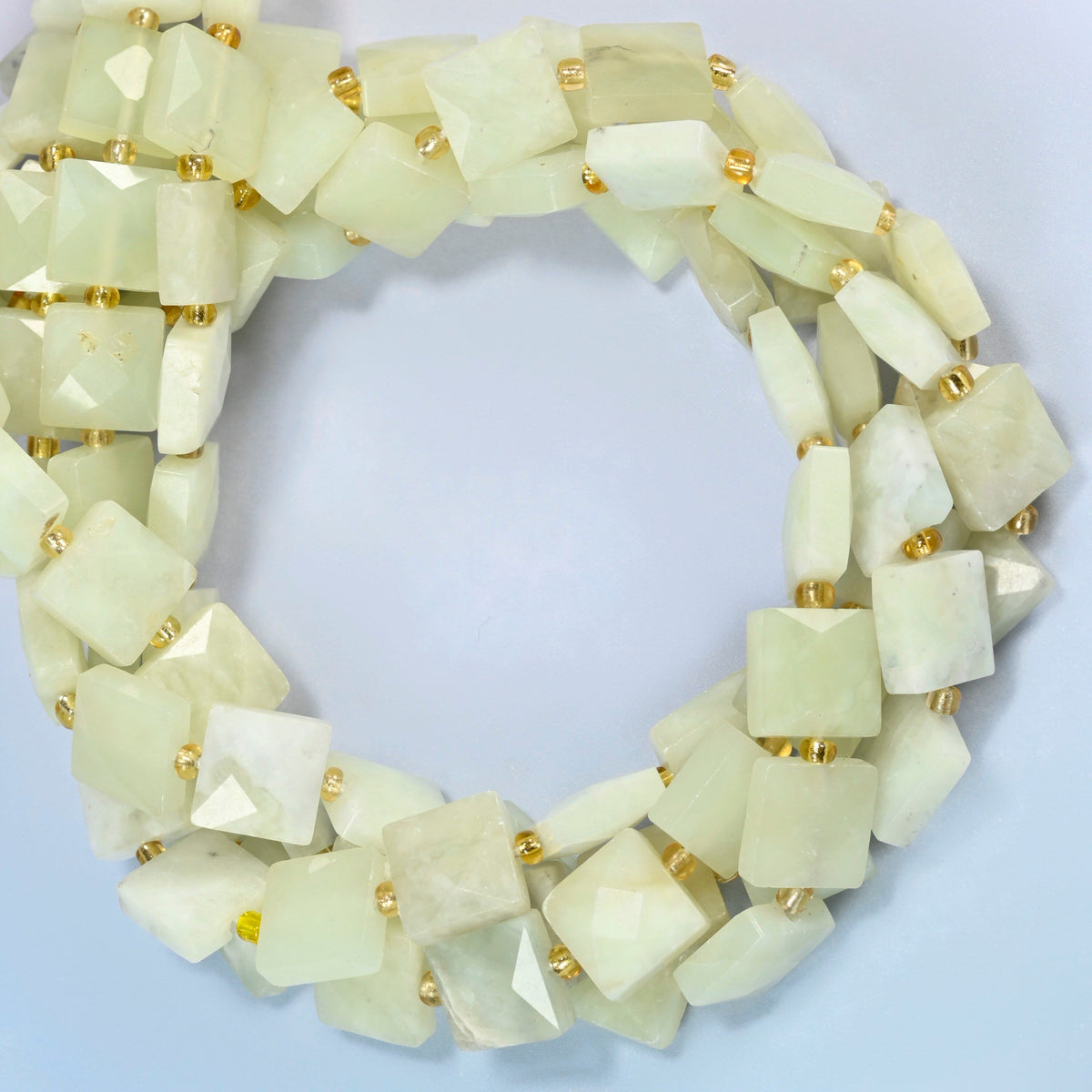New Jade faceted flat square beads coiled into overlapping loops, whole strands of soft yellow-green stone