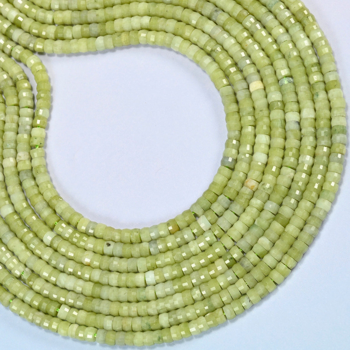 South Jade faceted heishi disc beads curved into an open loop, light yellow-green beads