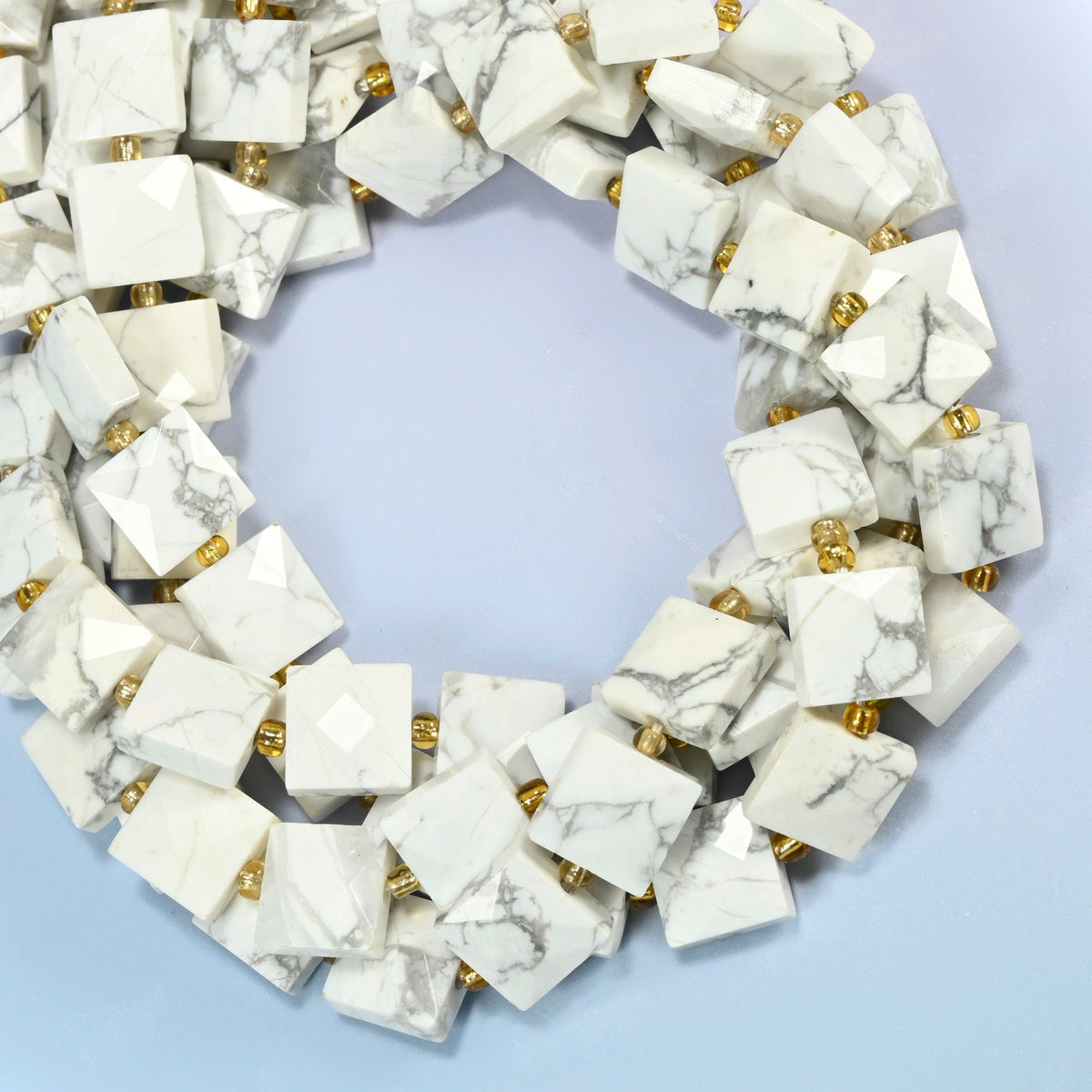 White howlite faceted flat square beads coiled into overlapping loops, whole strands of gray-veined white stone
