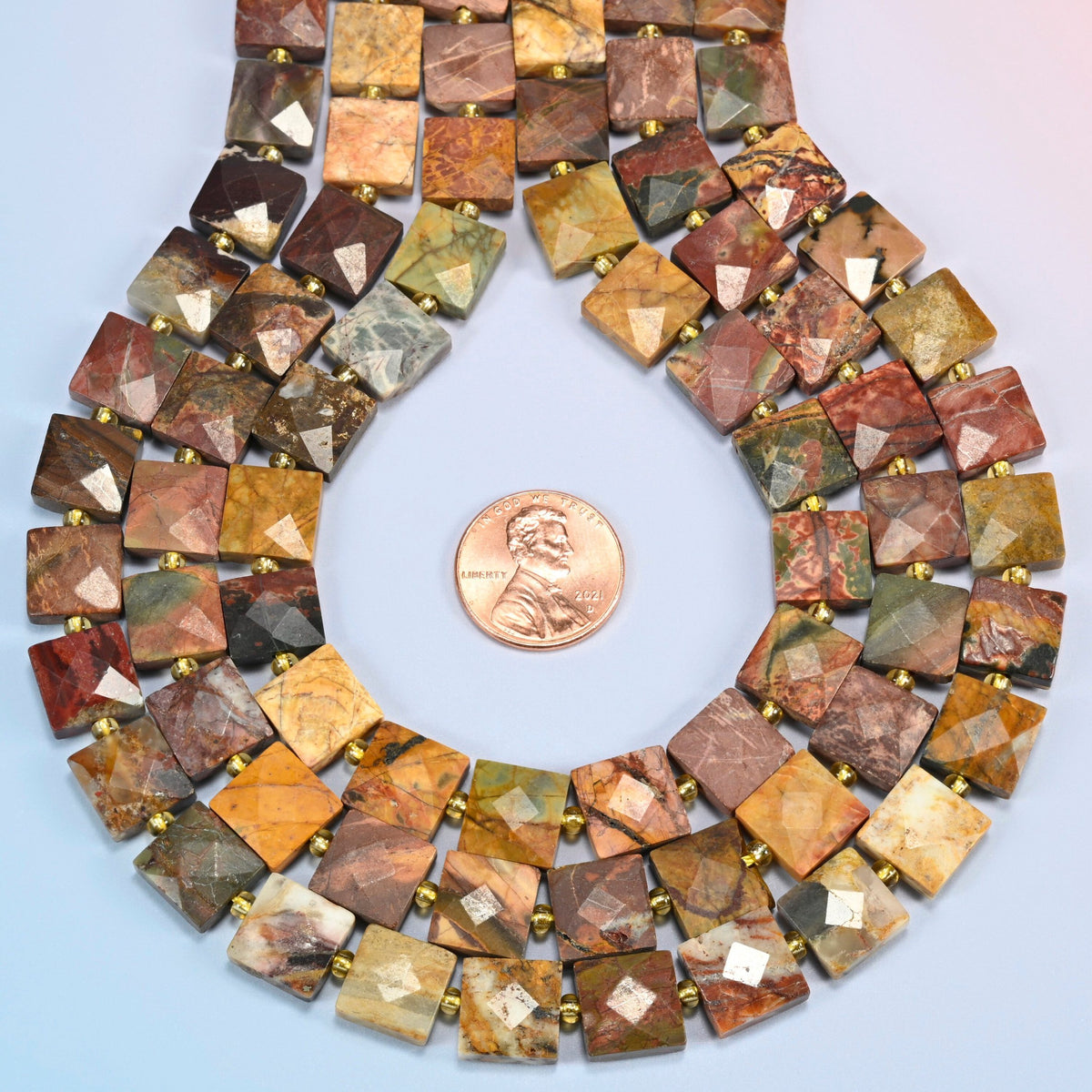 Natural red howlite faceted flat square strands formed into a teardrop loop around a US penny for scale