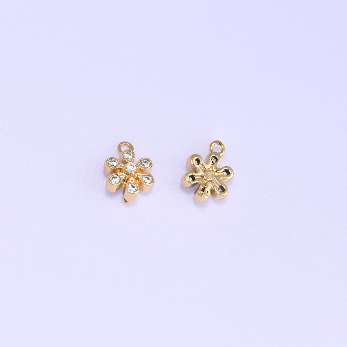 Small gold charms, two flower charms with one turned over to show the back