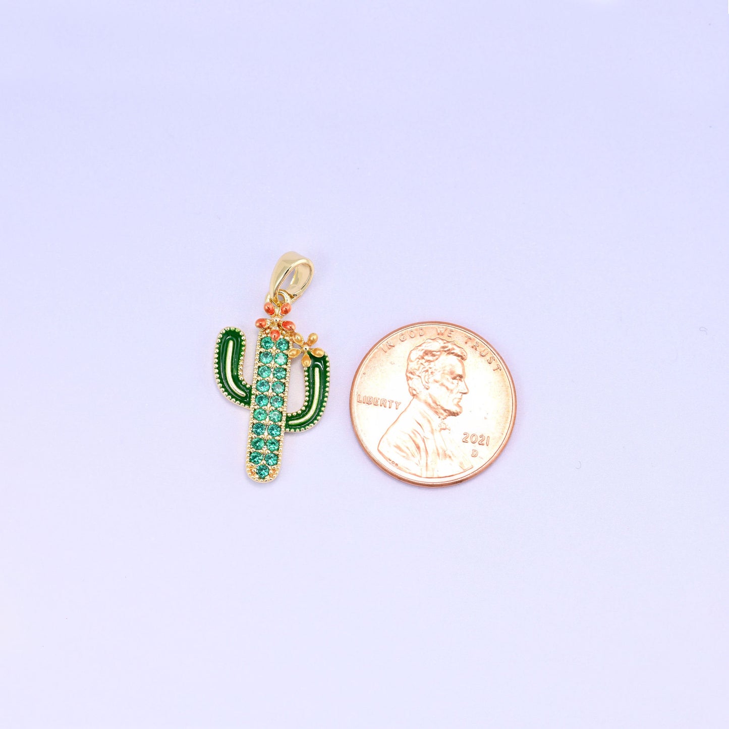 A little saguaro in green enamel with a pavé of green zircon running up the body and a coral blossom perched on one arm — desert kitsch done properly, in gold plated brass.