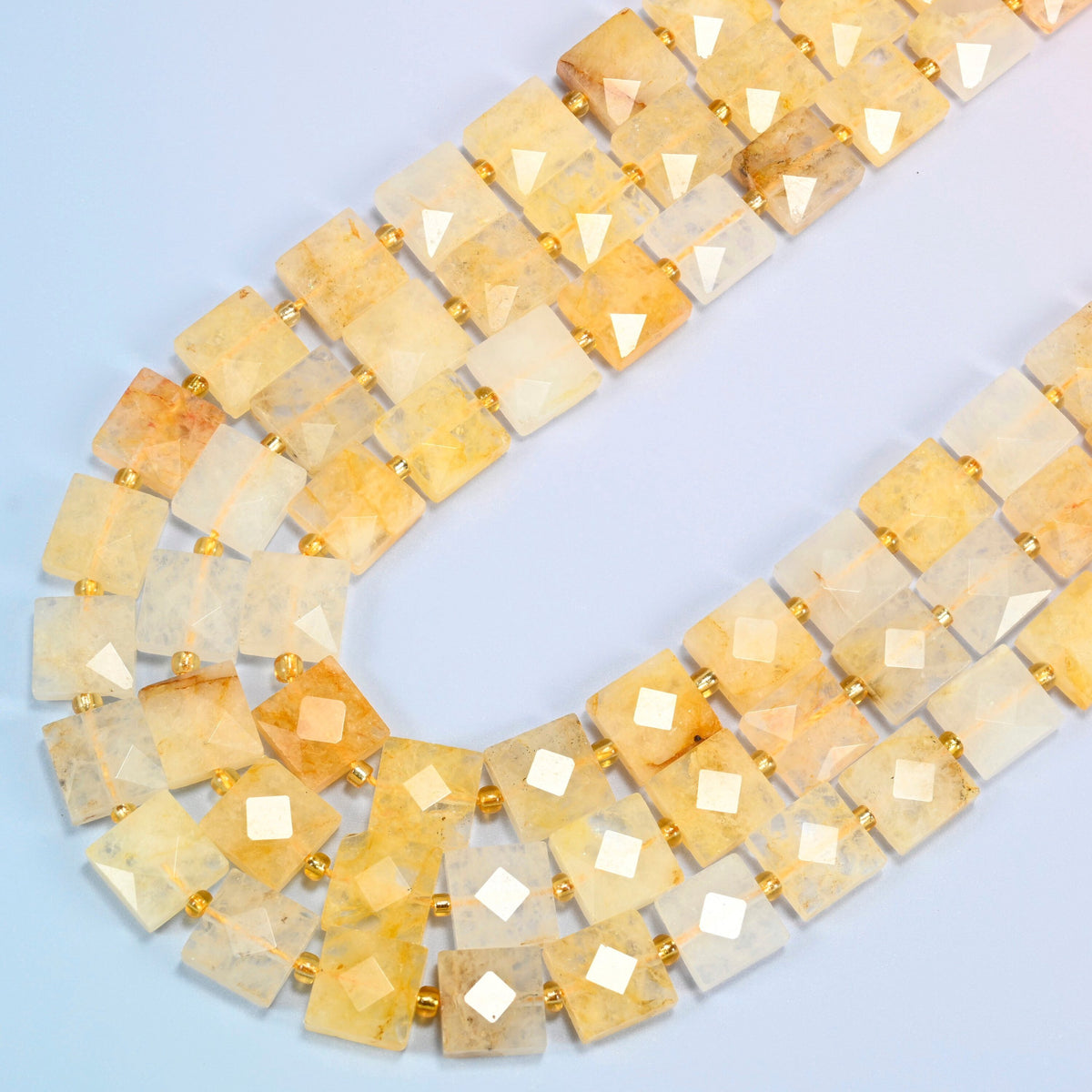 Natural golden healer quartz faceted flat square beads in several strands curved into a wide U, golden yellow, honey and cream stone