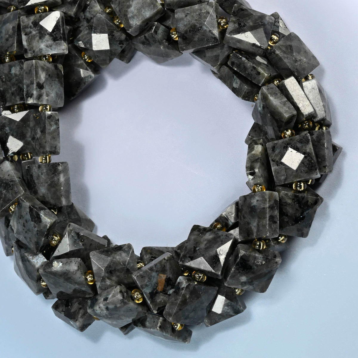 Natural black labradorite faceted flat square beads coiled into overlapping loops, whole strands of smoky gray stone