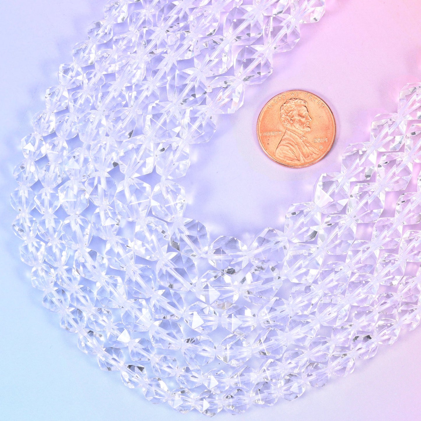 Clear Quartz diamond star cut beads coiled around a US penny, natural stone cut with star facets