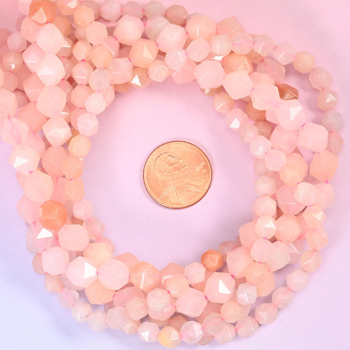 Pink Aventurine beads coiled around a US penny, hole size approximately 1.0mm, soft pink with peachy undertones