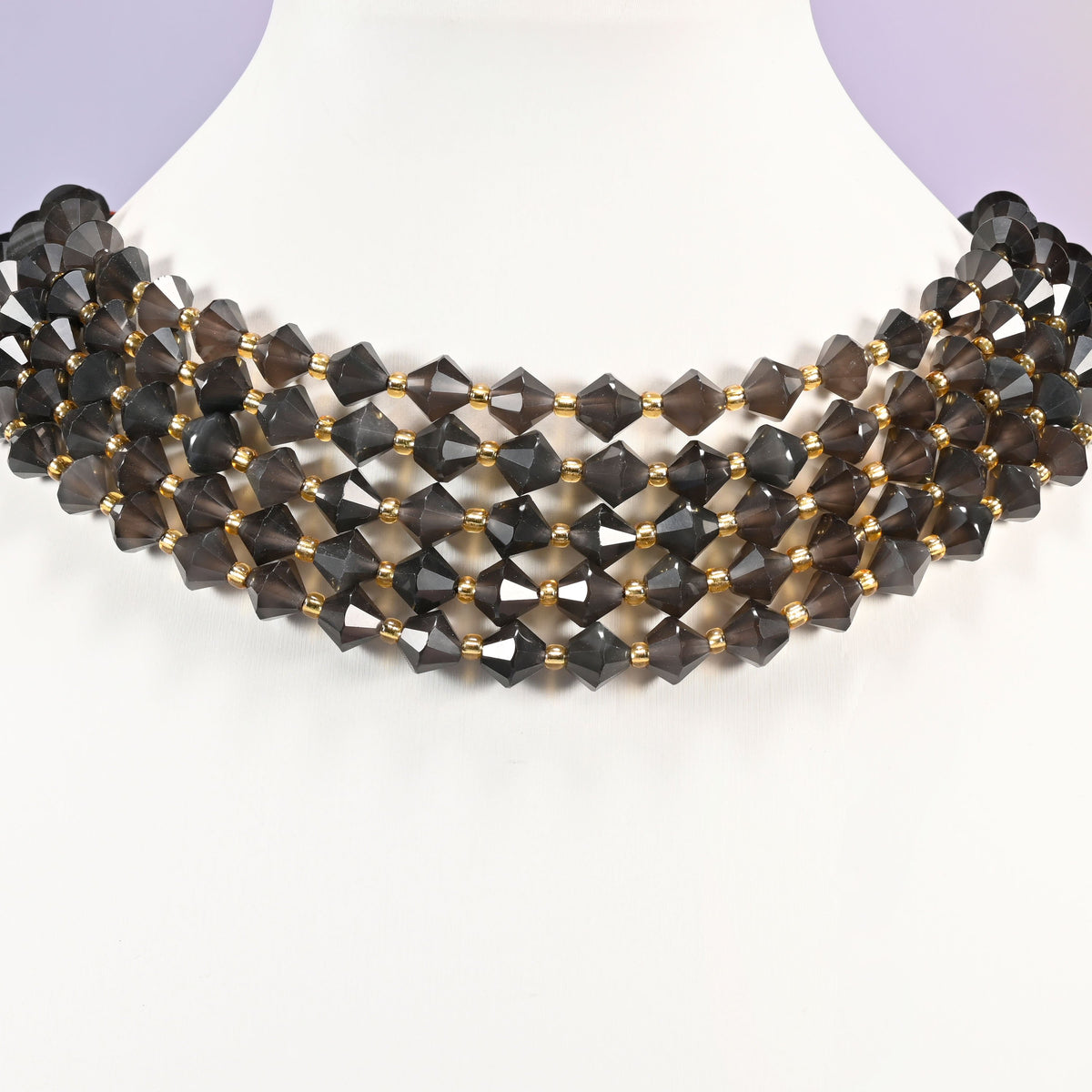 Ice Obsidian faceted bicone beads 8mm with gold-tone spacers, strand wrapped around a display bust like a choker necklace