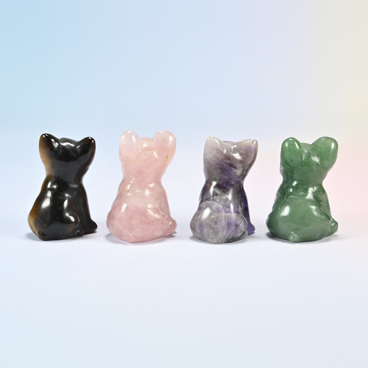 Back view of four French bulldog carvings in tiger eye, rose quartz, amethyst and green aventurine