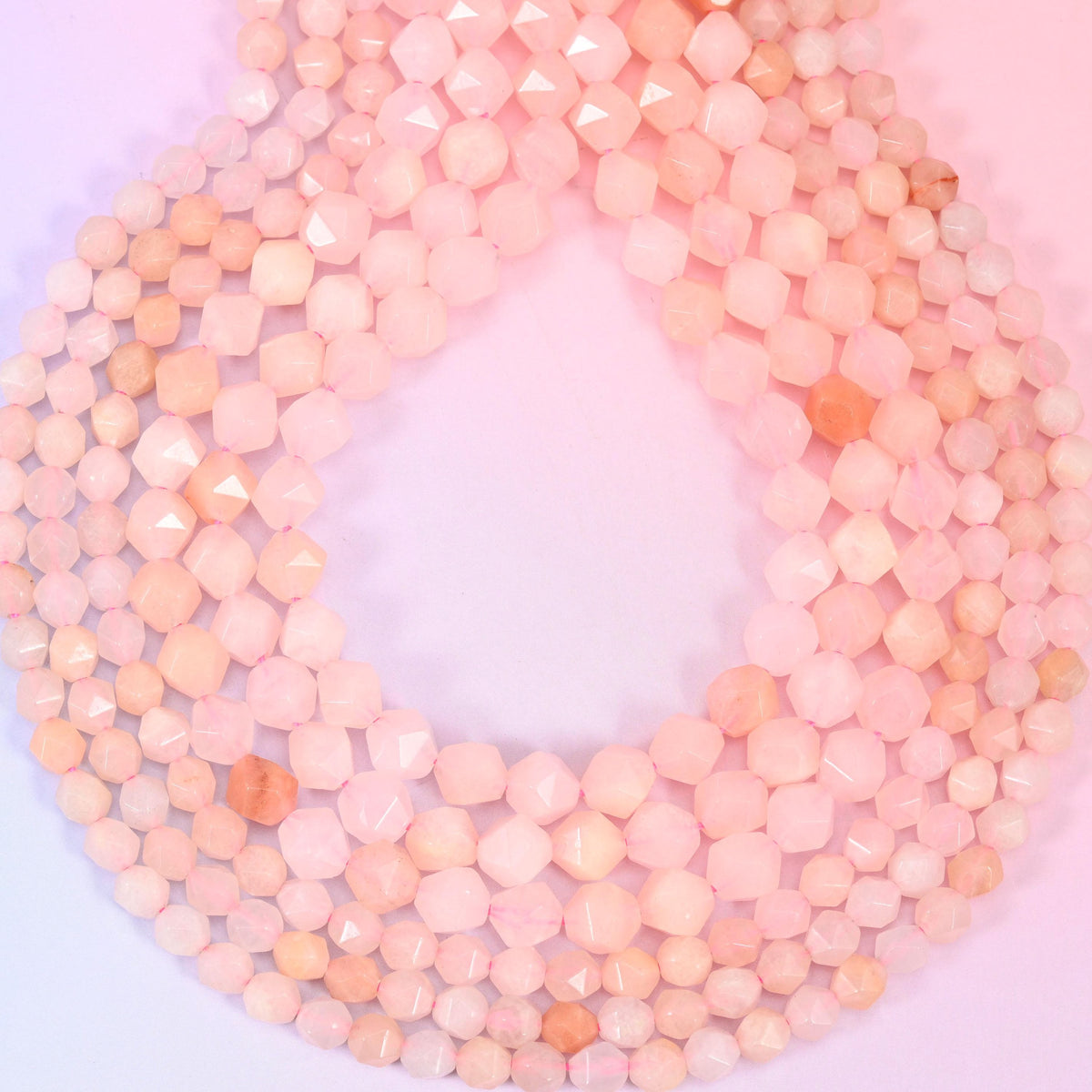 Pink Aventurine beads coiled into a loop, star facets catching light across the blush pink stone