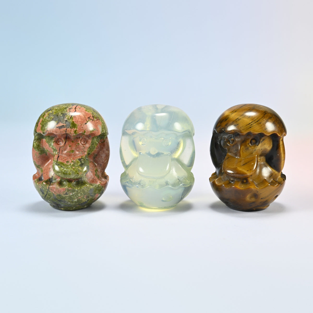 Three duck egg gemstone carvings in natural unakite, opalite (man-made glass) and natural tiger eye