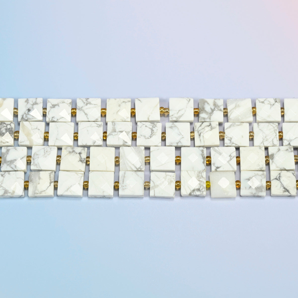 Several strands of white howlite faceted flat square beads laid in straight rows