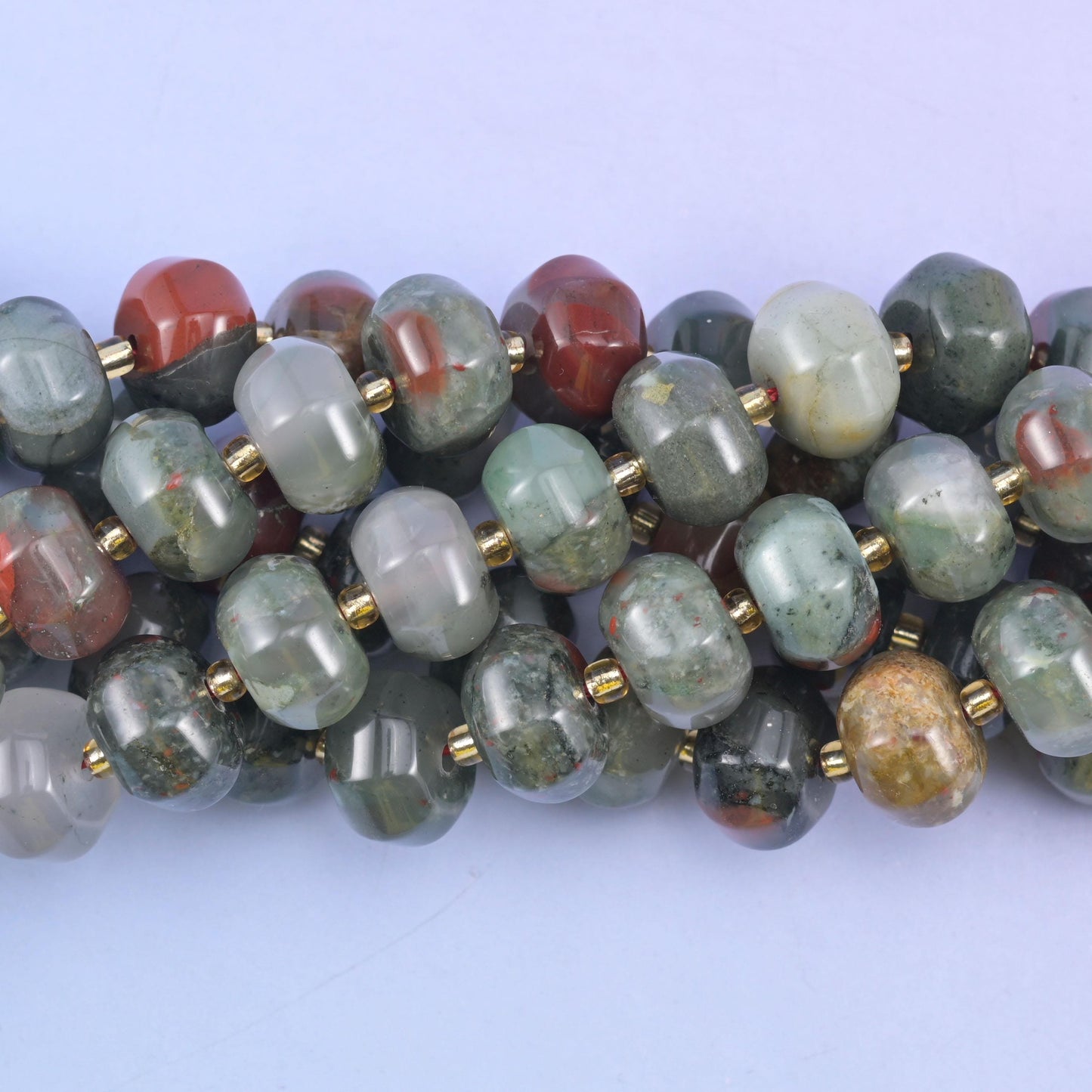 Close macro of african bloodstone pumpkin beads, a deep brick-red bead among the grey-green ones