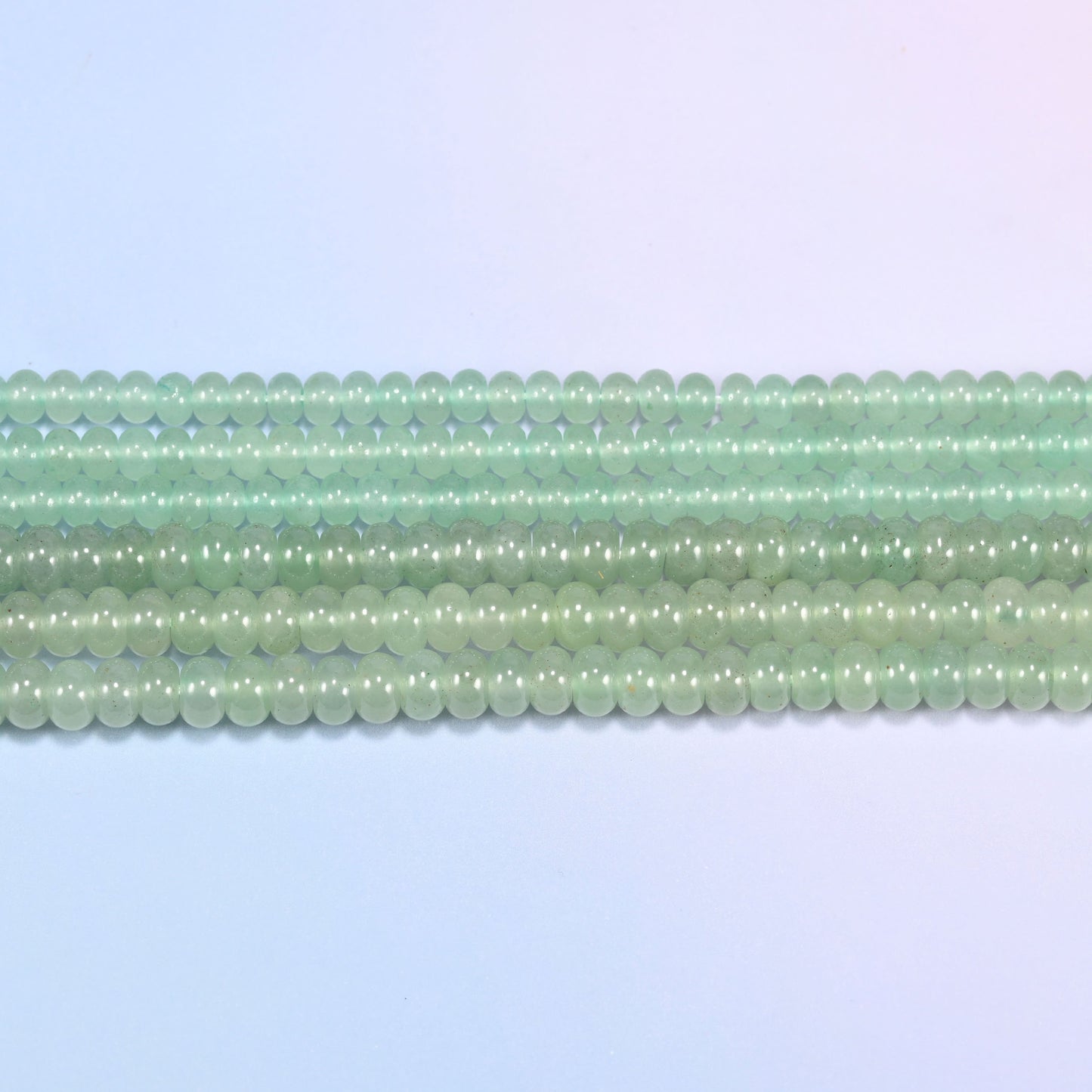 Green Aventurine gemstone rondelle beads in straight rows, showing the flat disc profile and centre drilling