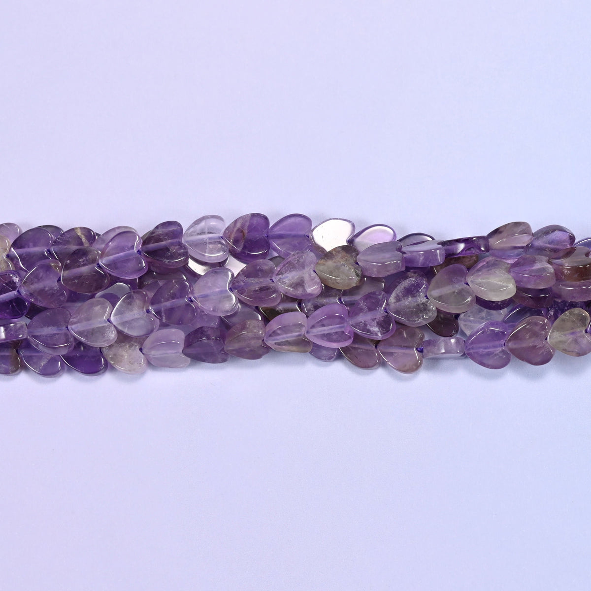 Translucent lilac and violet with smoky grey and near-clear hearts mixed through, cut flat at just 2mm thick so a close-strung row lies almost like beadwork.